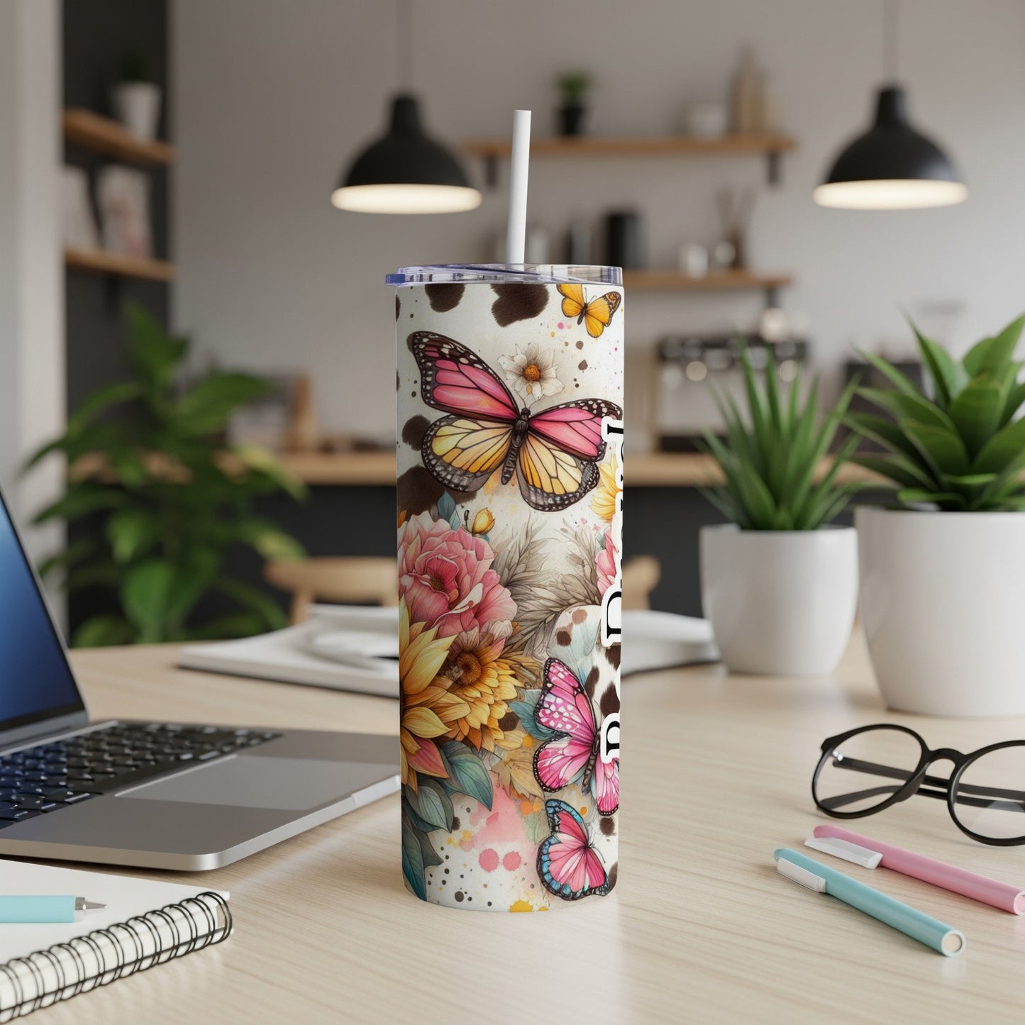 Tumbler with butterflies, flowers, and cow print design.