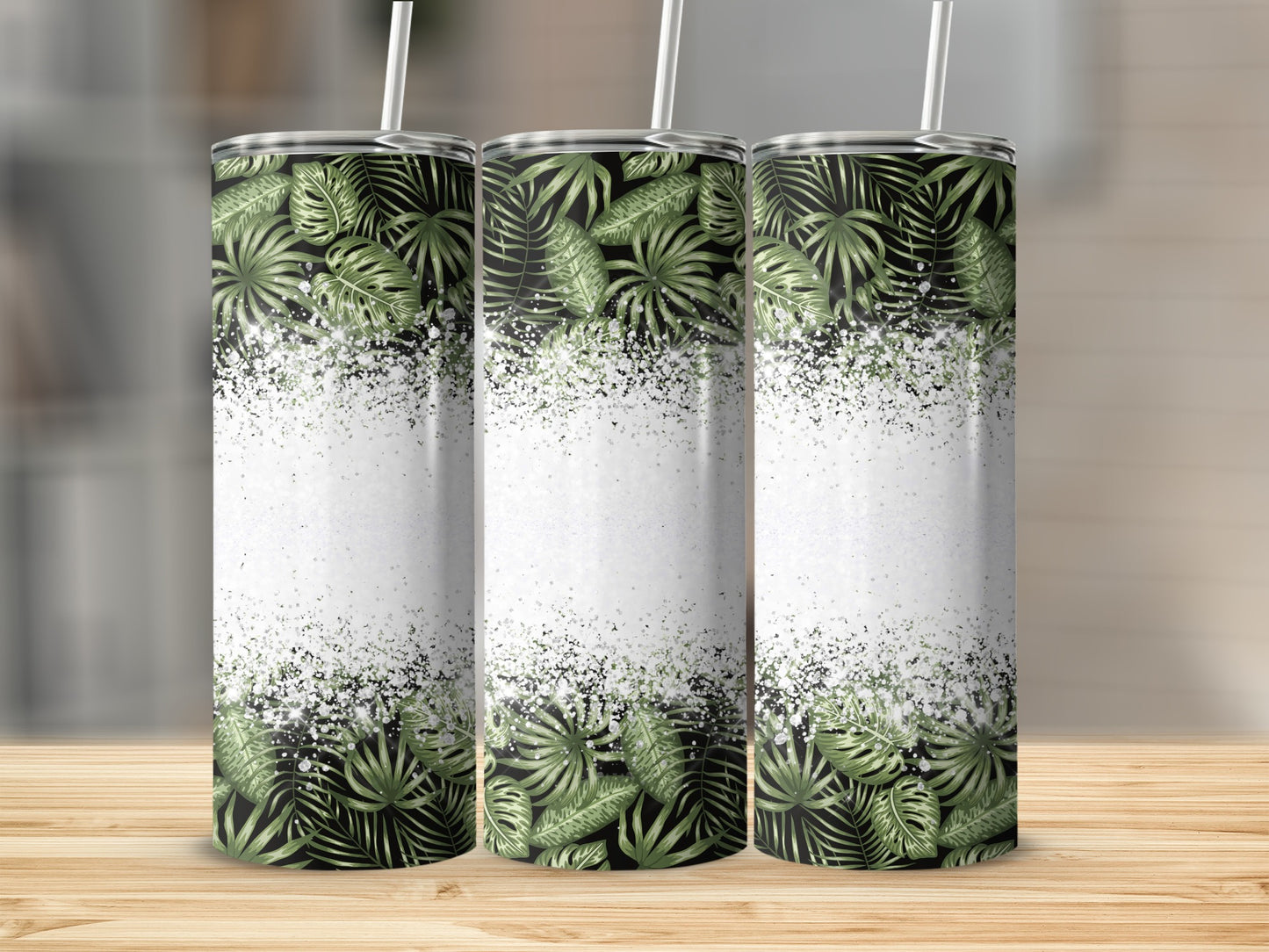 Three tumblers with tropical green leaves and white glitter design.