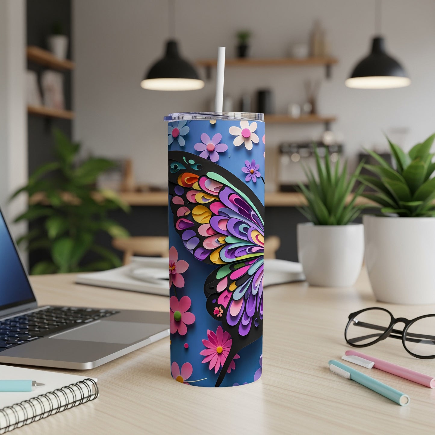 Blue tumbler with colorful butterfly and flower design, straw in place.