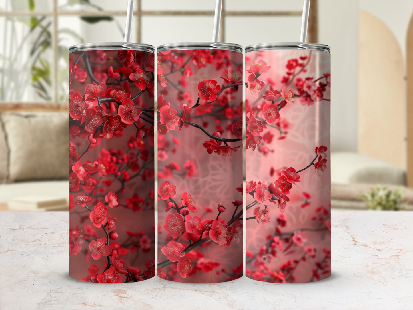 Three tumblers with a red cherry blossom floral pattern on a white marble surface.