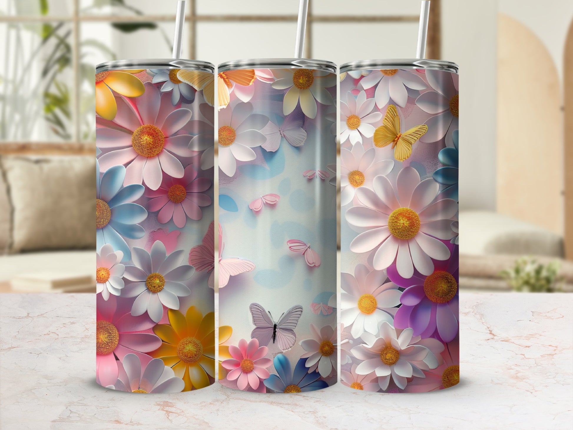Three tumblers with colorful floral and butterfly designs on a marbled surface.