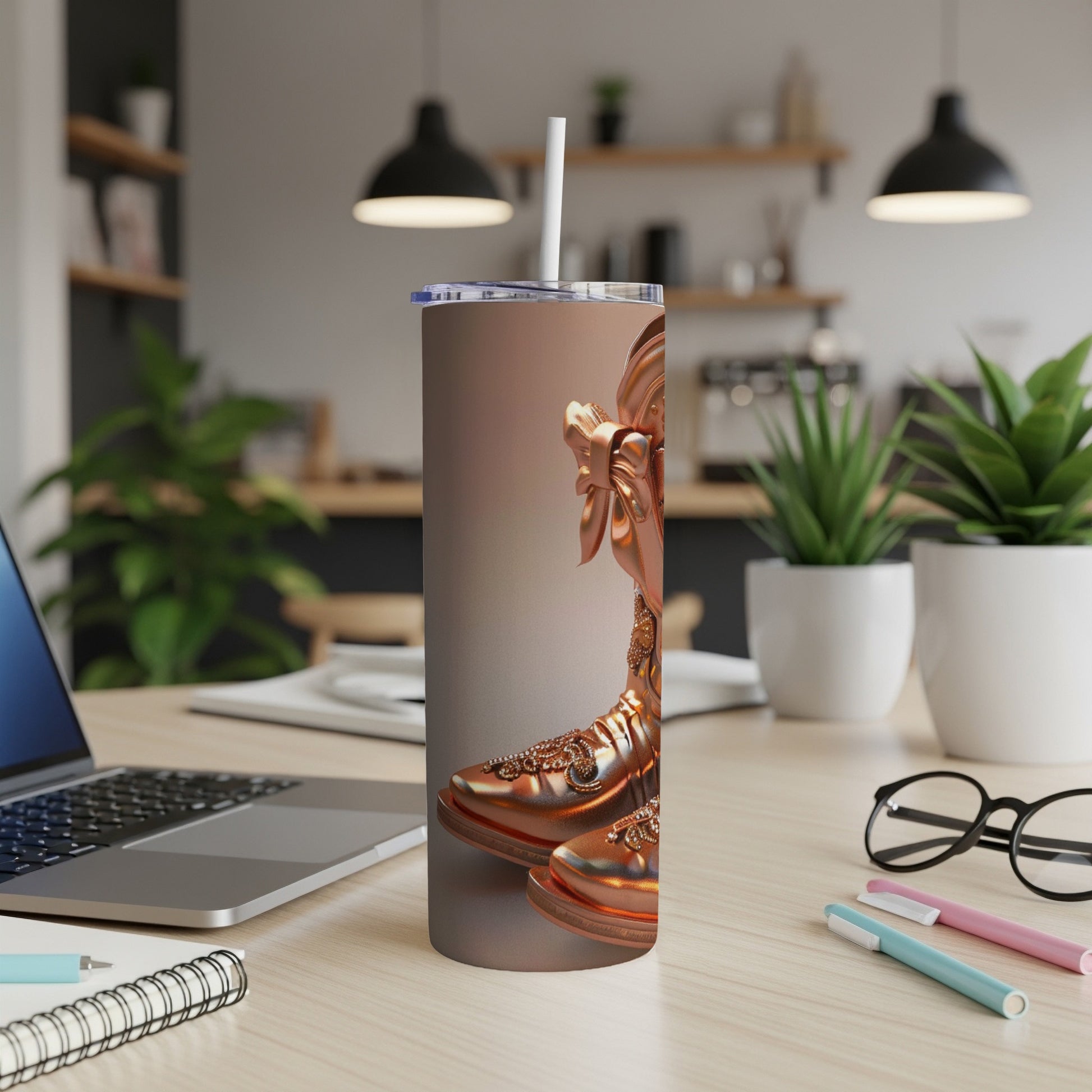Copper tumbler with ornate patterned lid and straw on a desk.