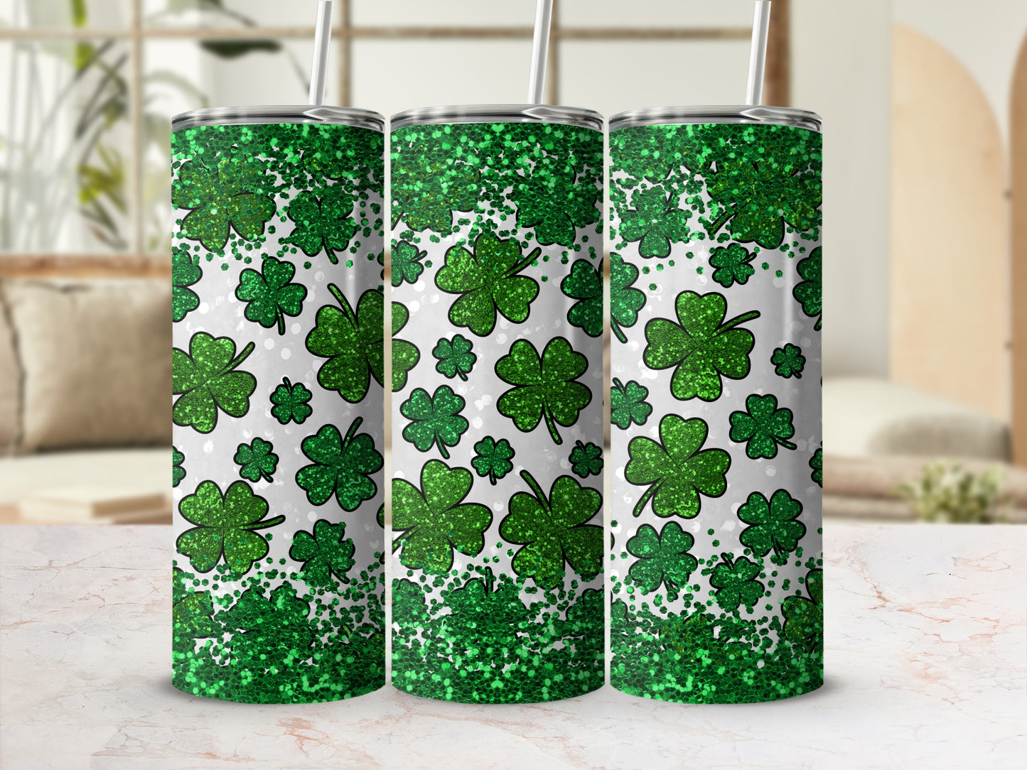 Three tumblers with green glitter and shamrocks on a blurred background.