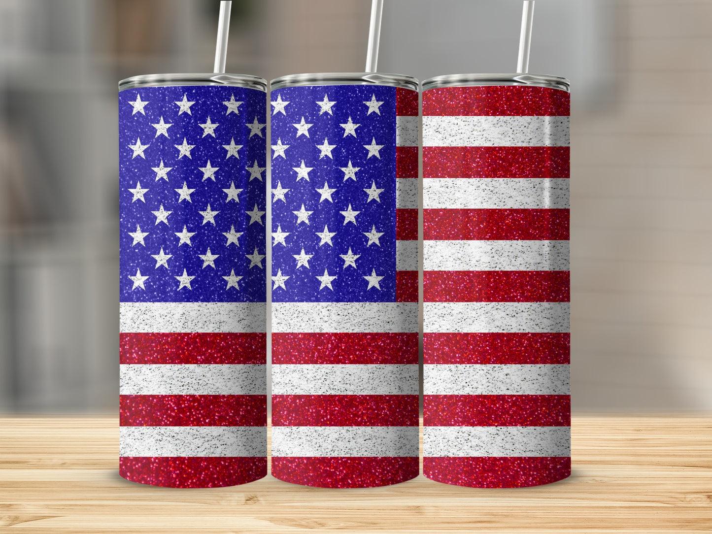 Three tumblers with glittery American flag design on a wooden surface.