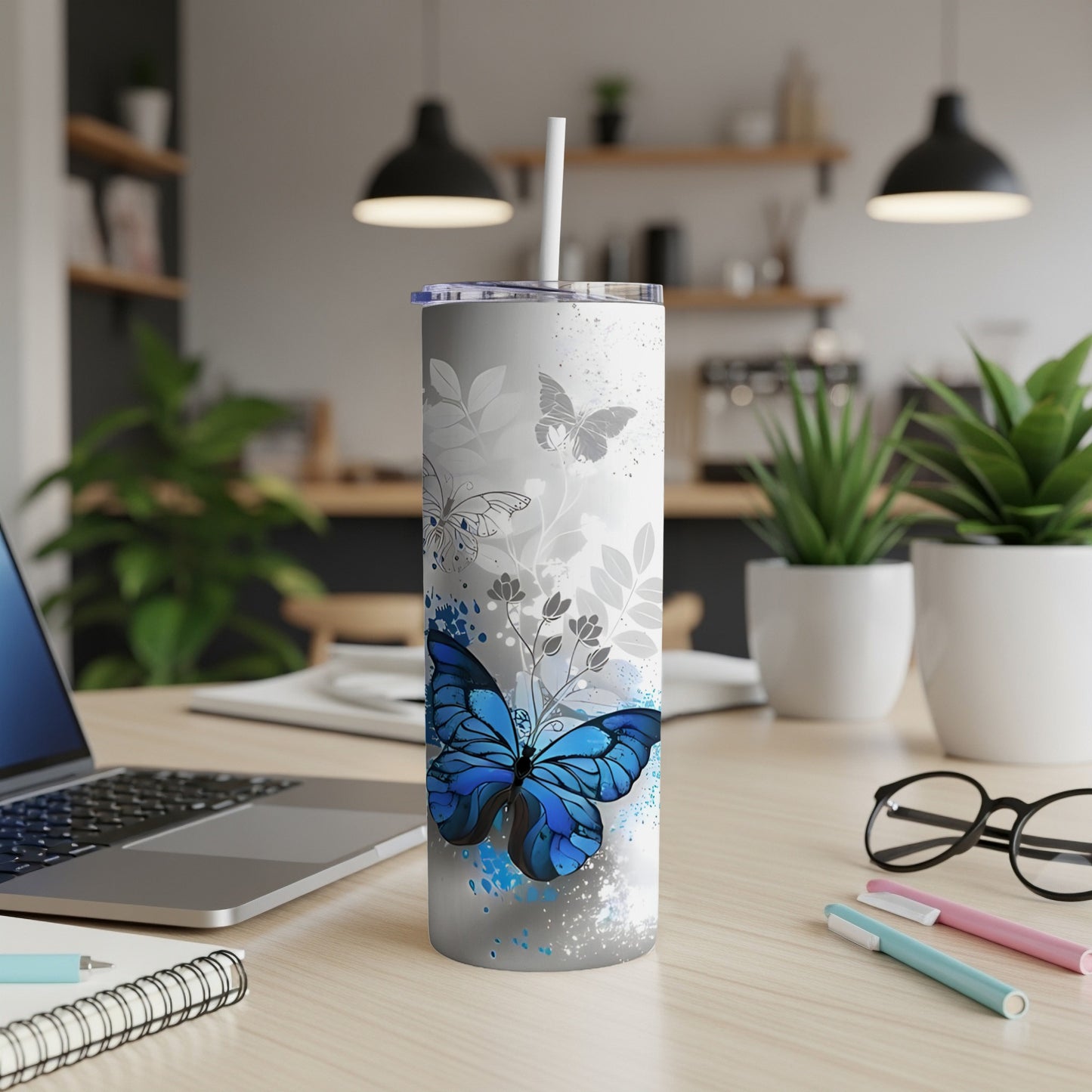 Blue butterfly and floral design on a white tumbler with straw.