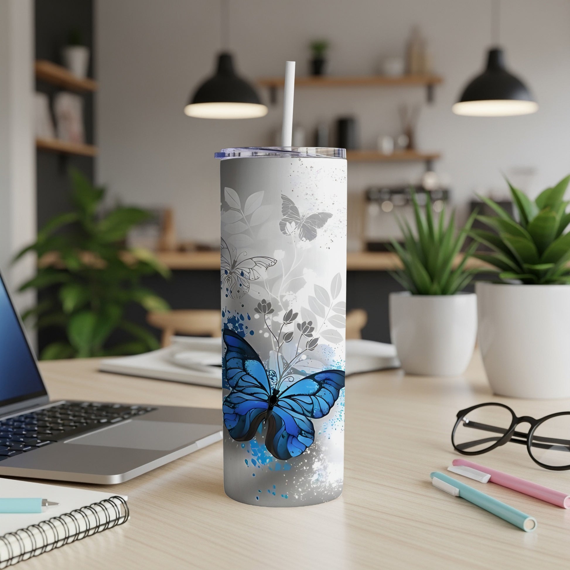 Blue butterfly and floral design on a white tumbler with straw.