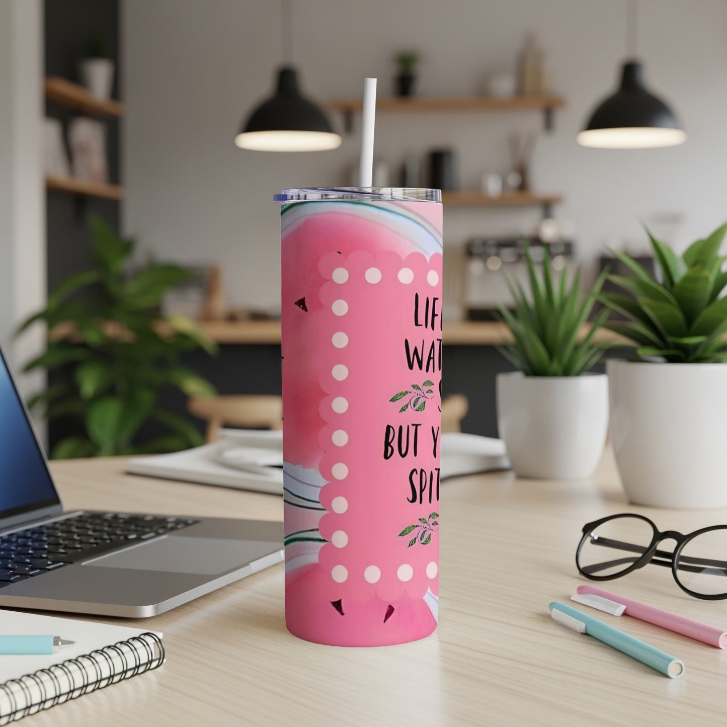 Pink marbled tumbler with "Life is what you bake it" text on a desk.
