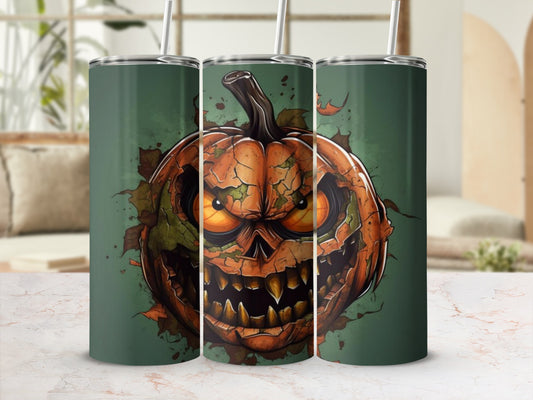 Tumbler with cracked jack-o'-lantern face and autumn leaves on green background.