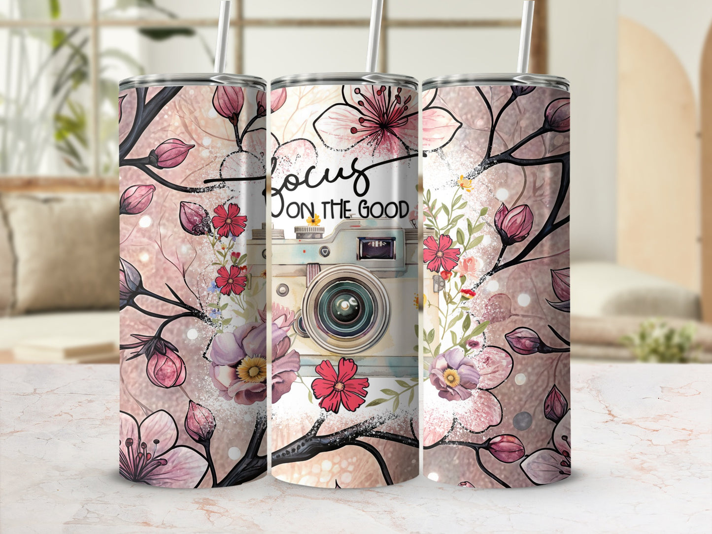 Floral tumbler with vintage camera and "focus on the good" text.