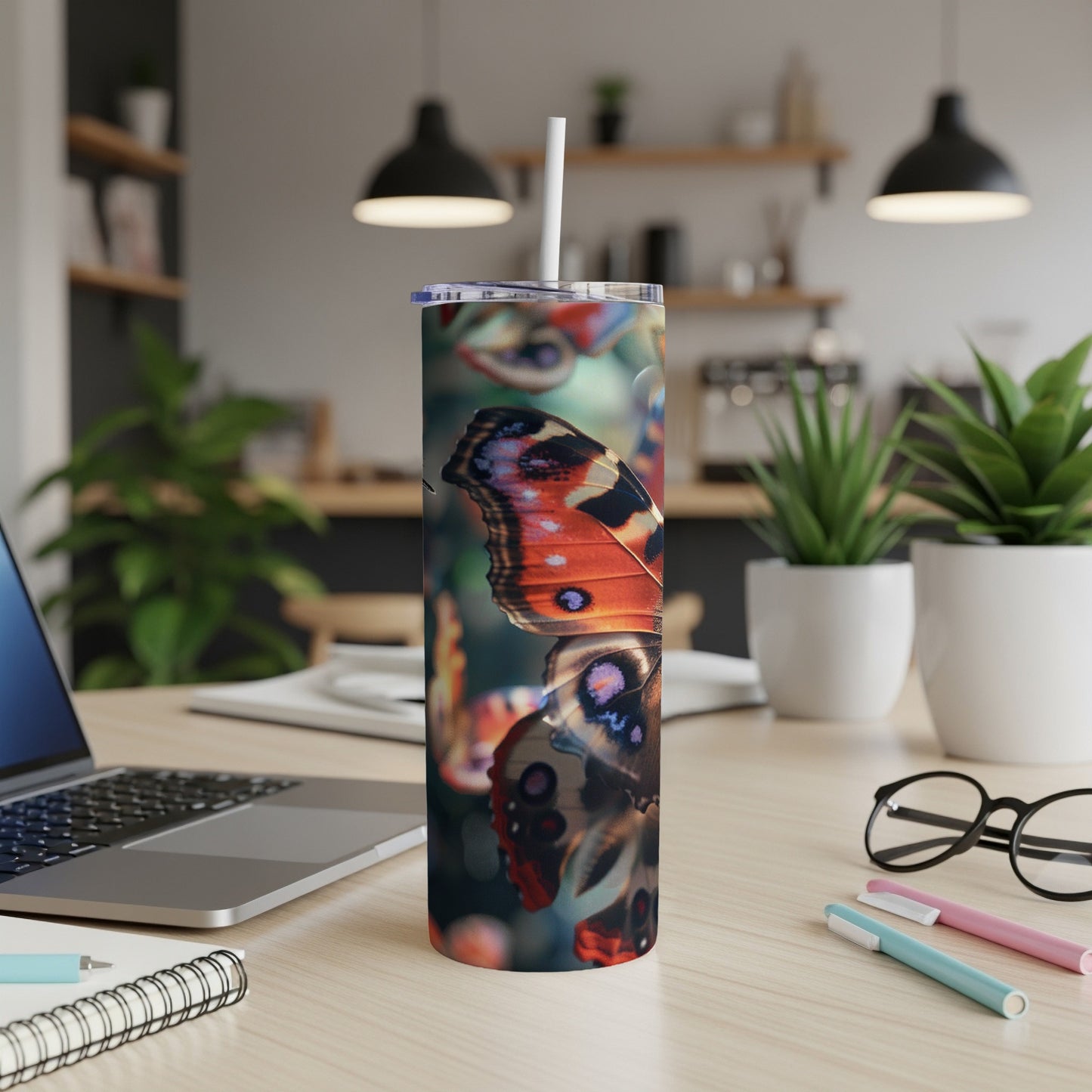 Close-up of butterfly wings on a tall tumbler with a straw.