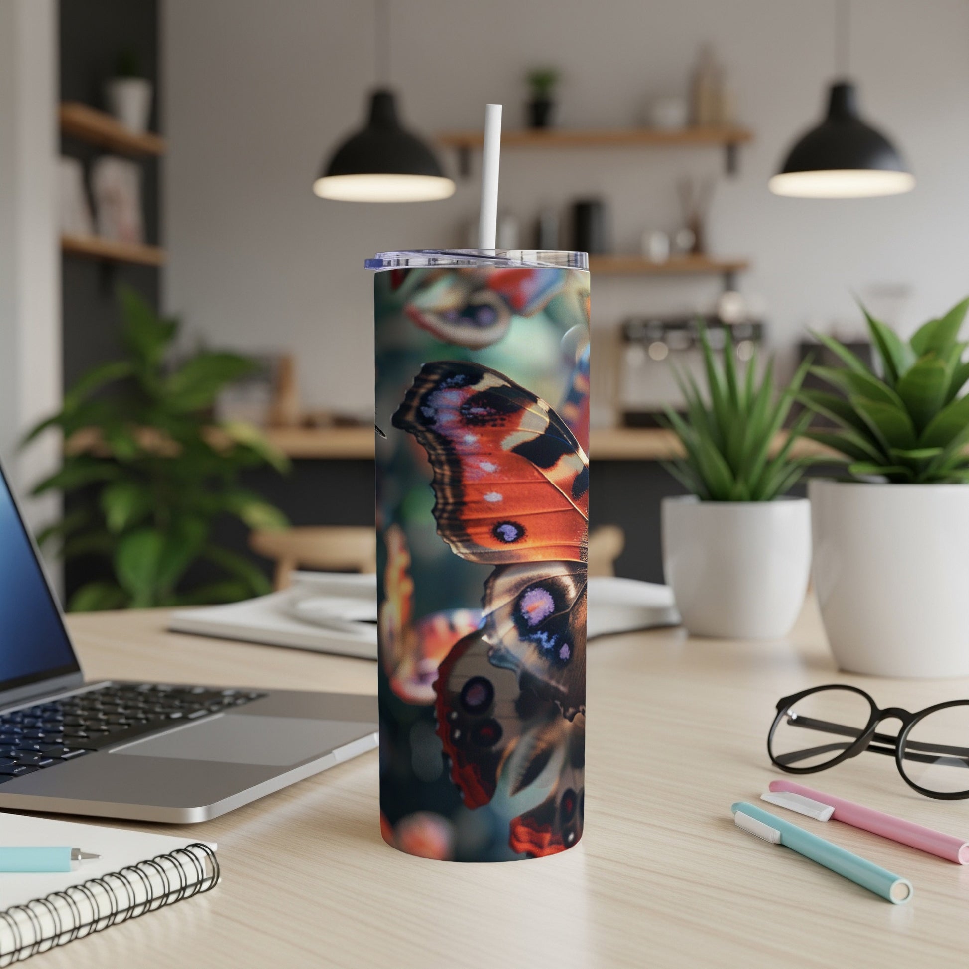Close-up of butterfly wings on a tall tumbler with a straw.