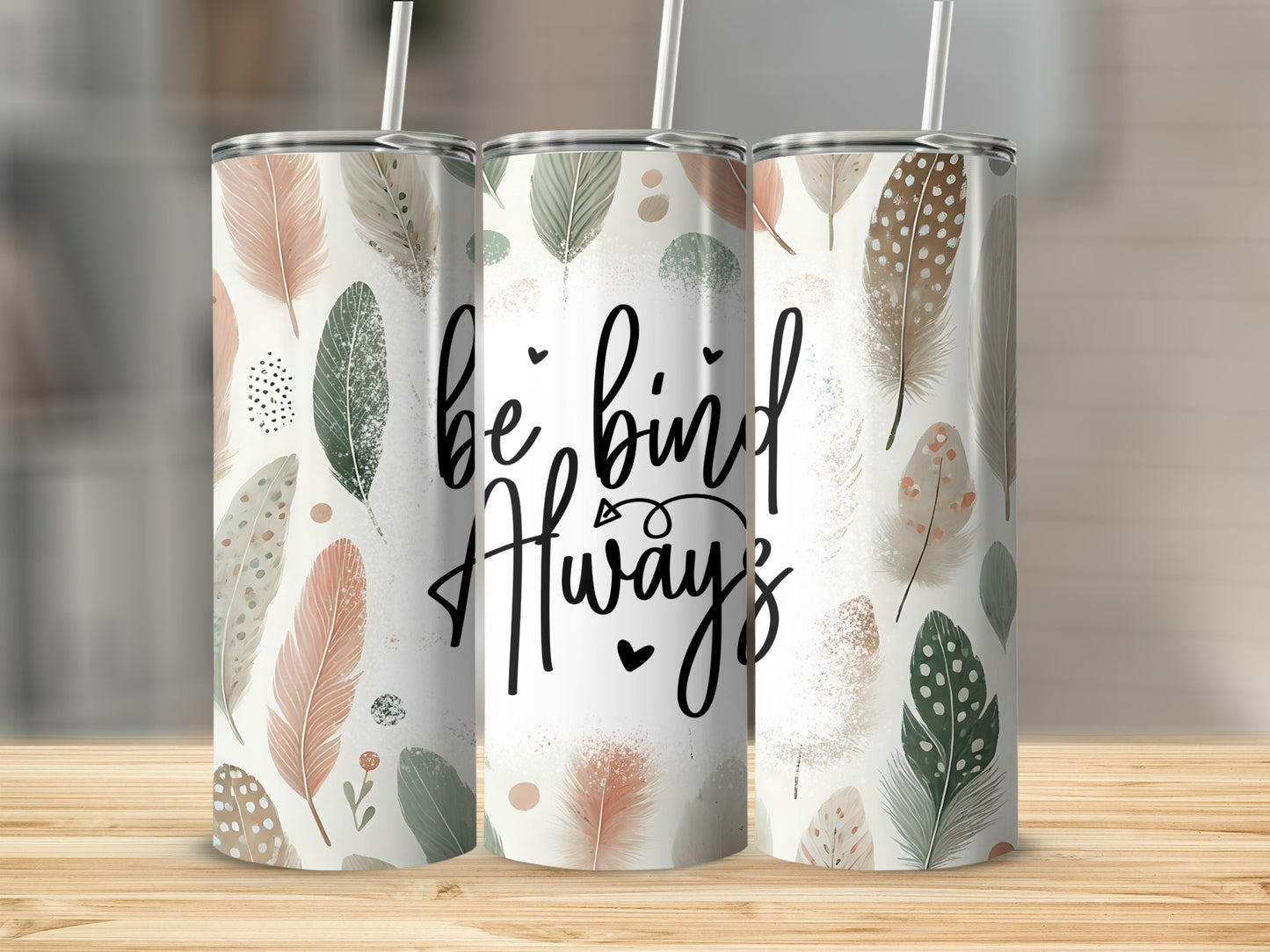 Tumbler with feathers and "be kind always" text on a wooden surface.