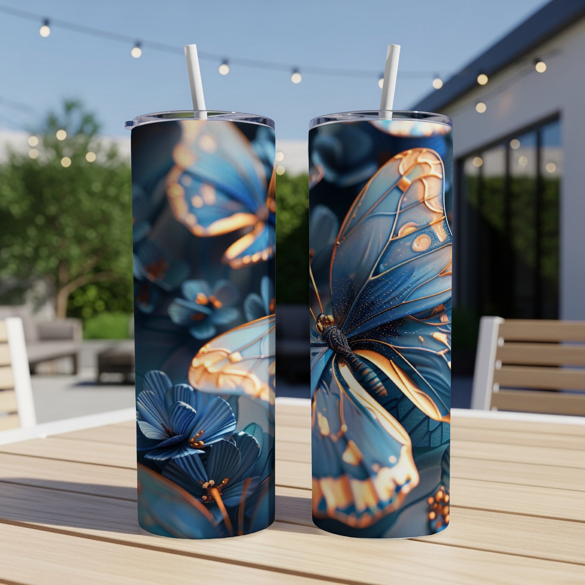 Two blue and gold patterned tumblers with straws on a wooden table.