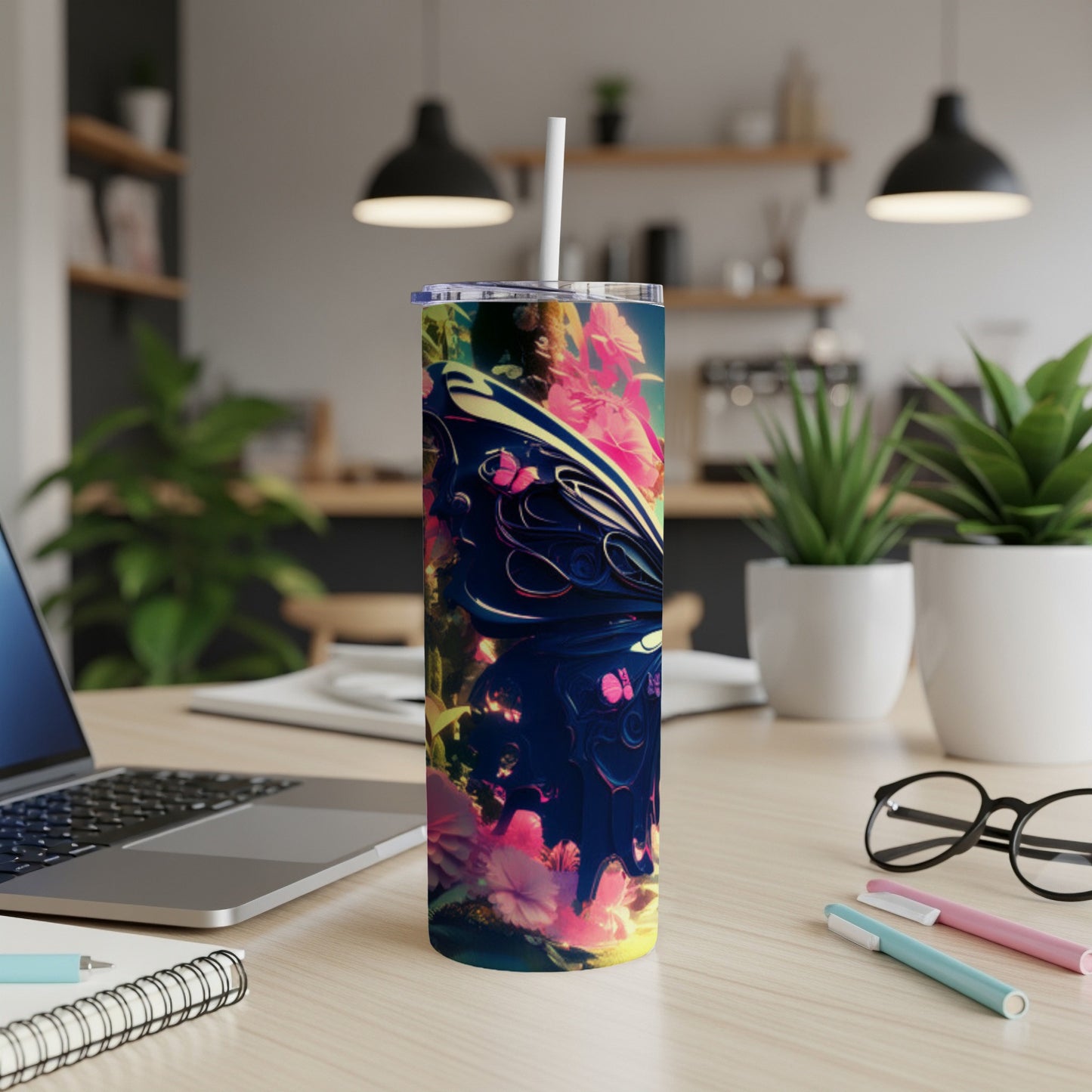 Tall tumbler with butterfly and floral design on a wooden desk.