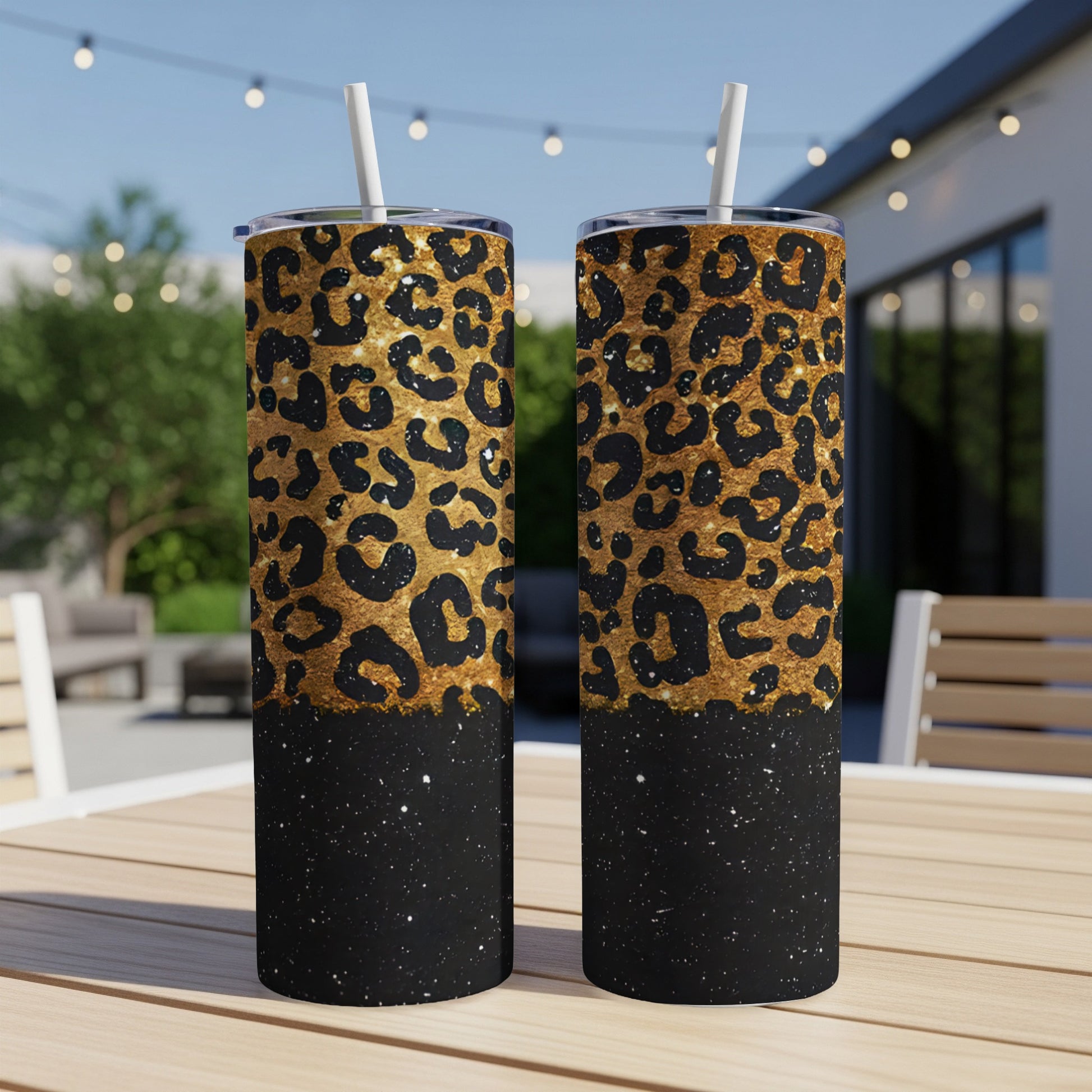 Two tall, gold leopard print tumblers with black glitter base and straws.
