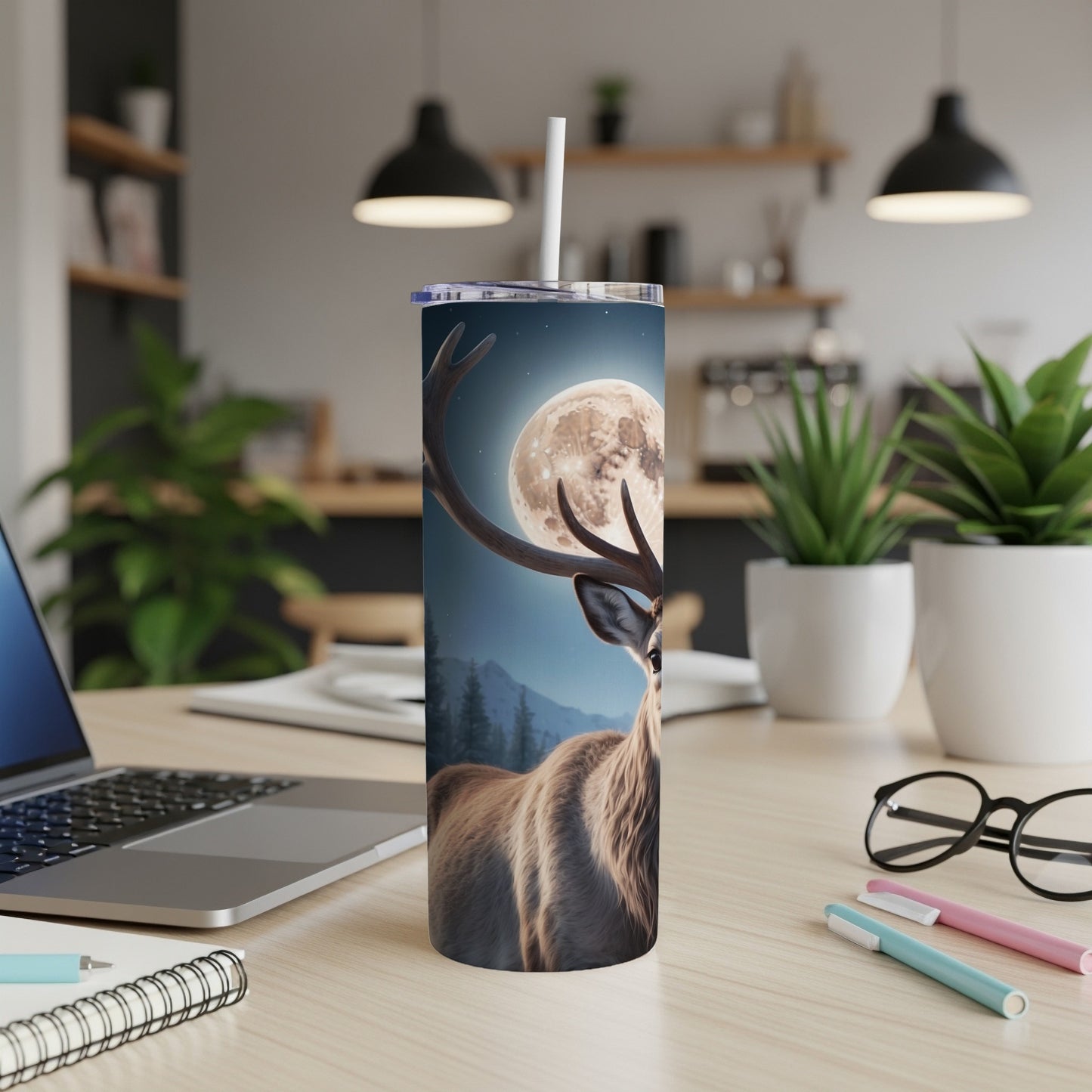Deer with full moon on tumbler, placed on a desk.