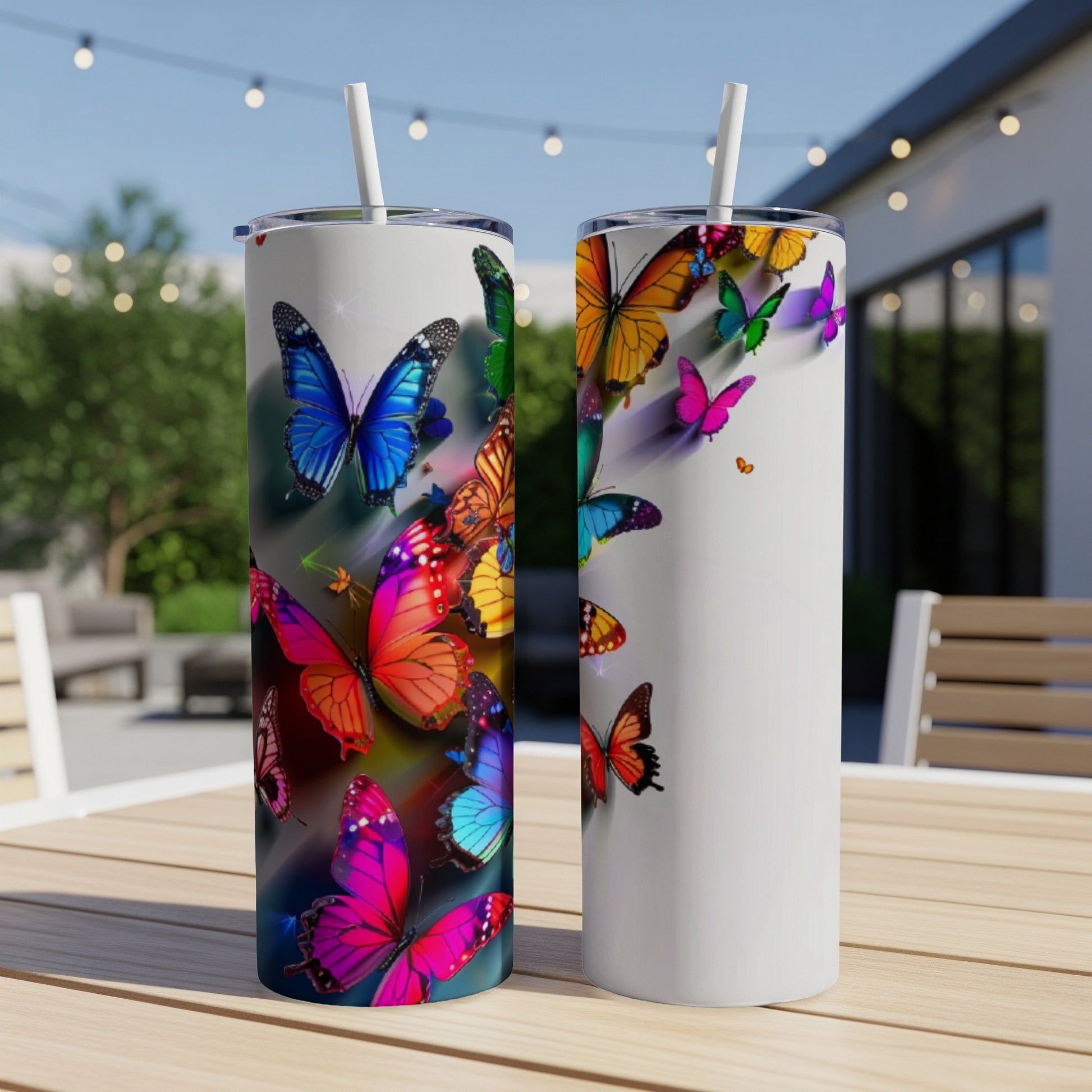 Two tall tumblers adorned with colorful butterfly designs on a wooden table.