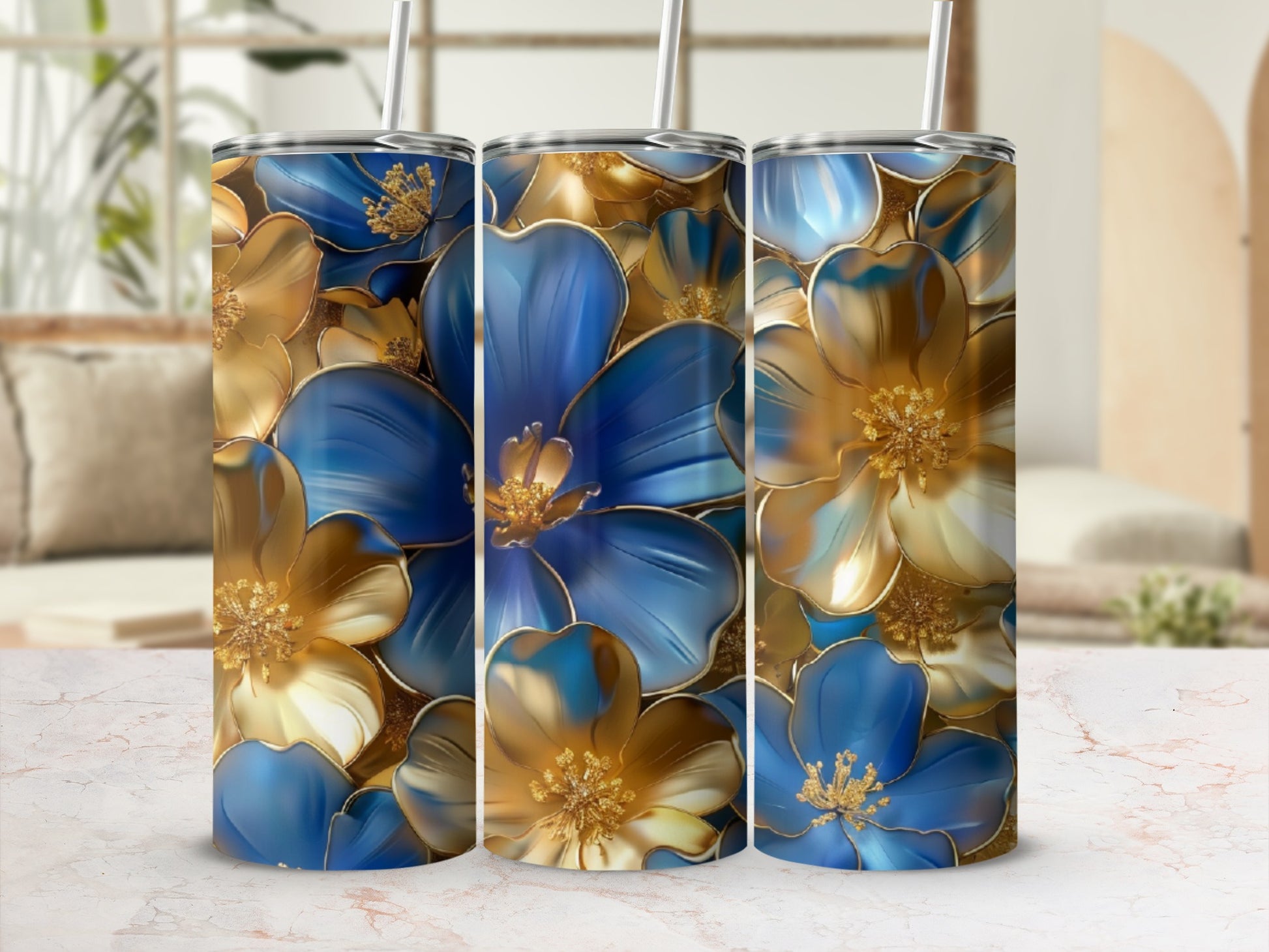 Three tumblers with blue and gold floral patterns on a marble surface.