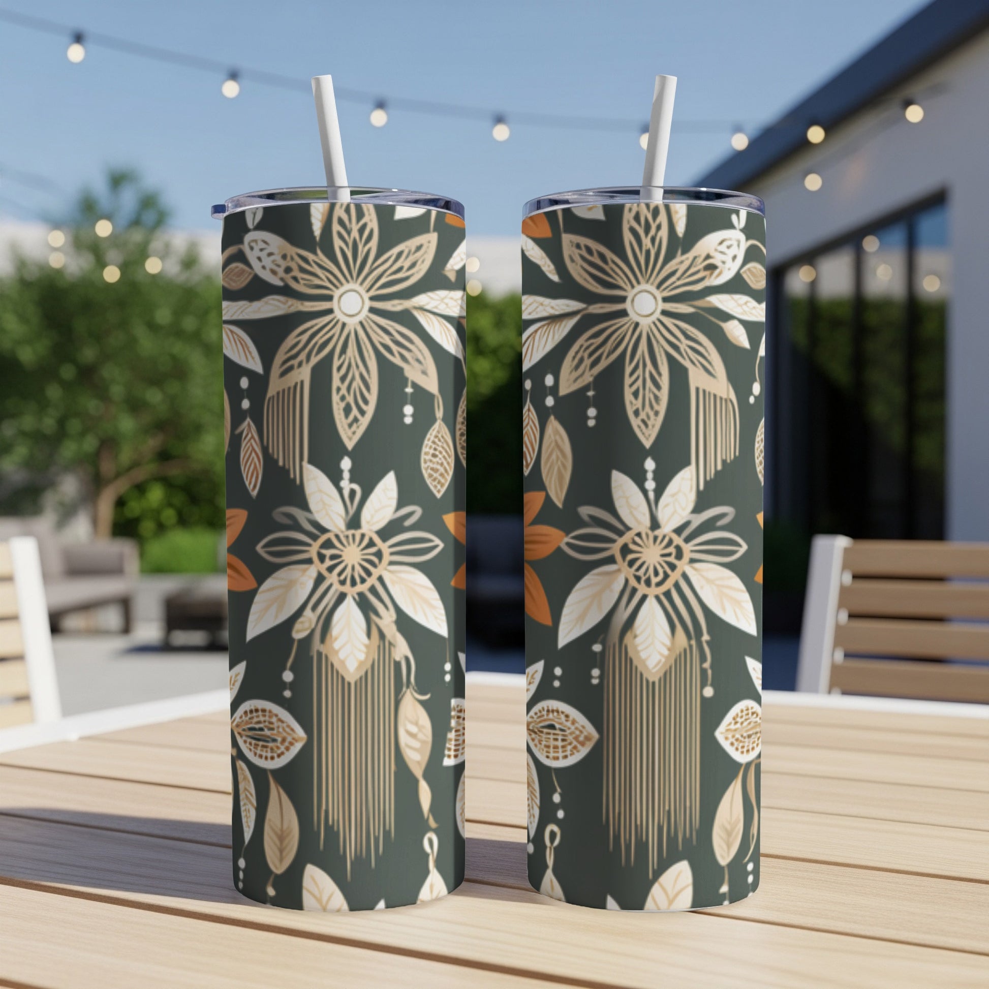Two dark green tumblers with a gold and white floral and feather pattern.