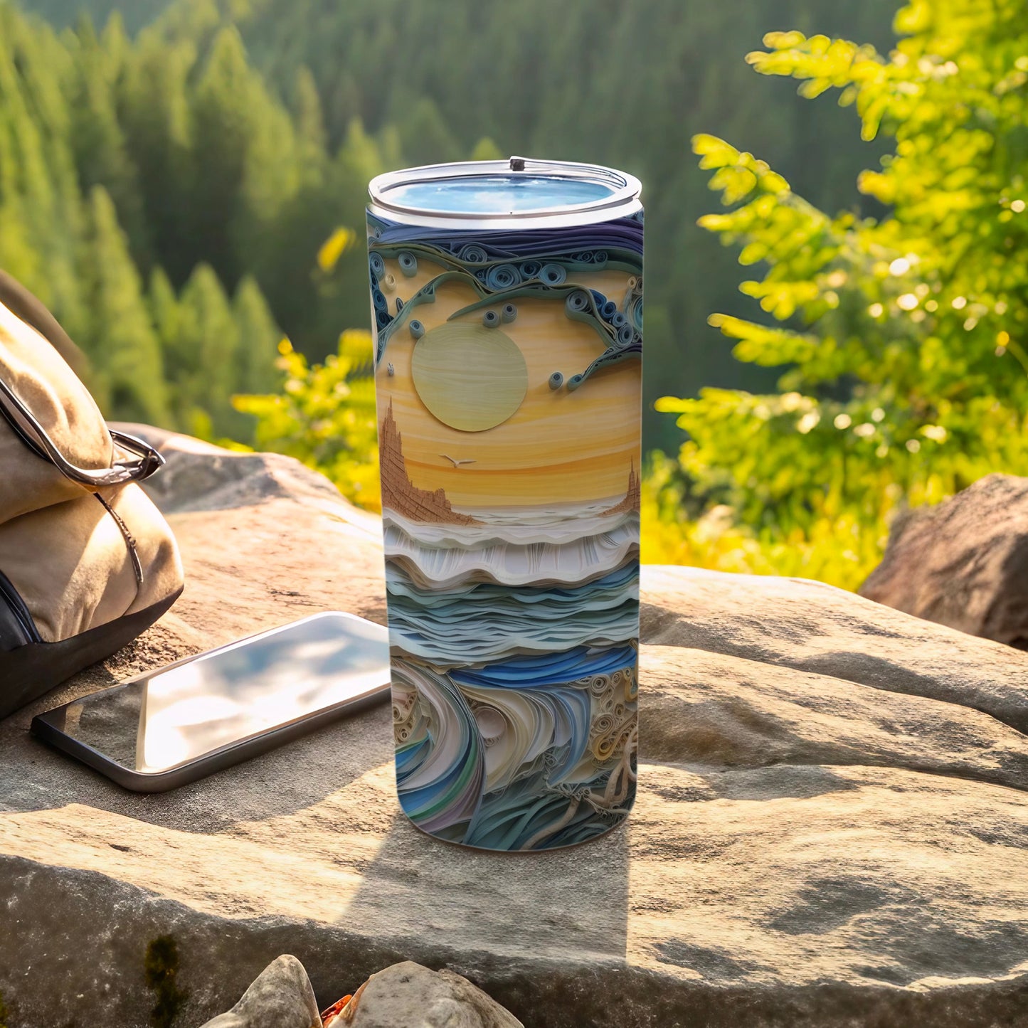 Quilling art tumbler with swirling sky, ocean, and land, on a rock.