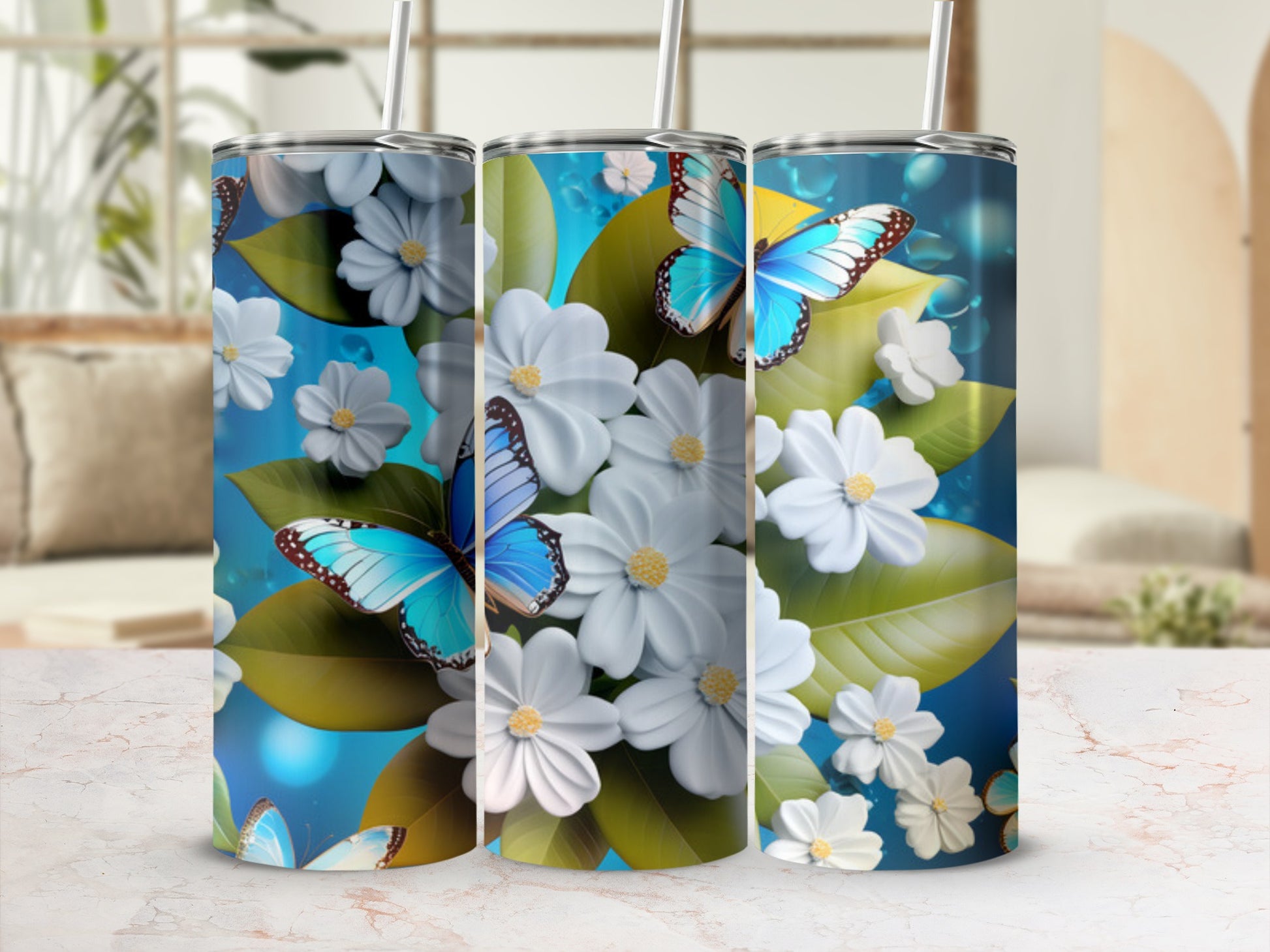 Three tall tumblers with blue butterflies and white flowers on a blue background.