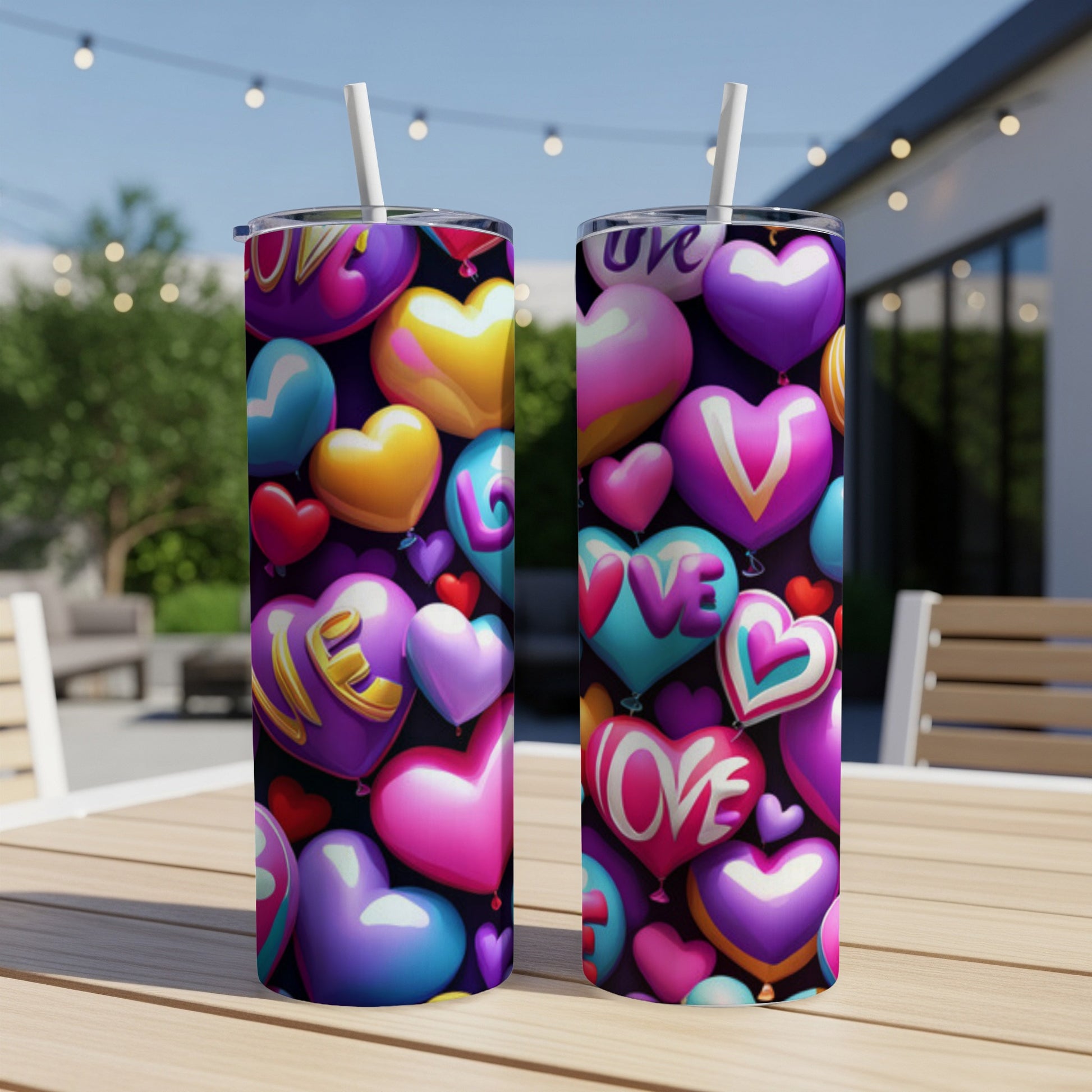 Two insulated tumblers covered in colorful heart-shaped balloons.