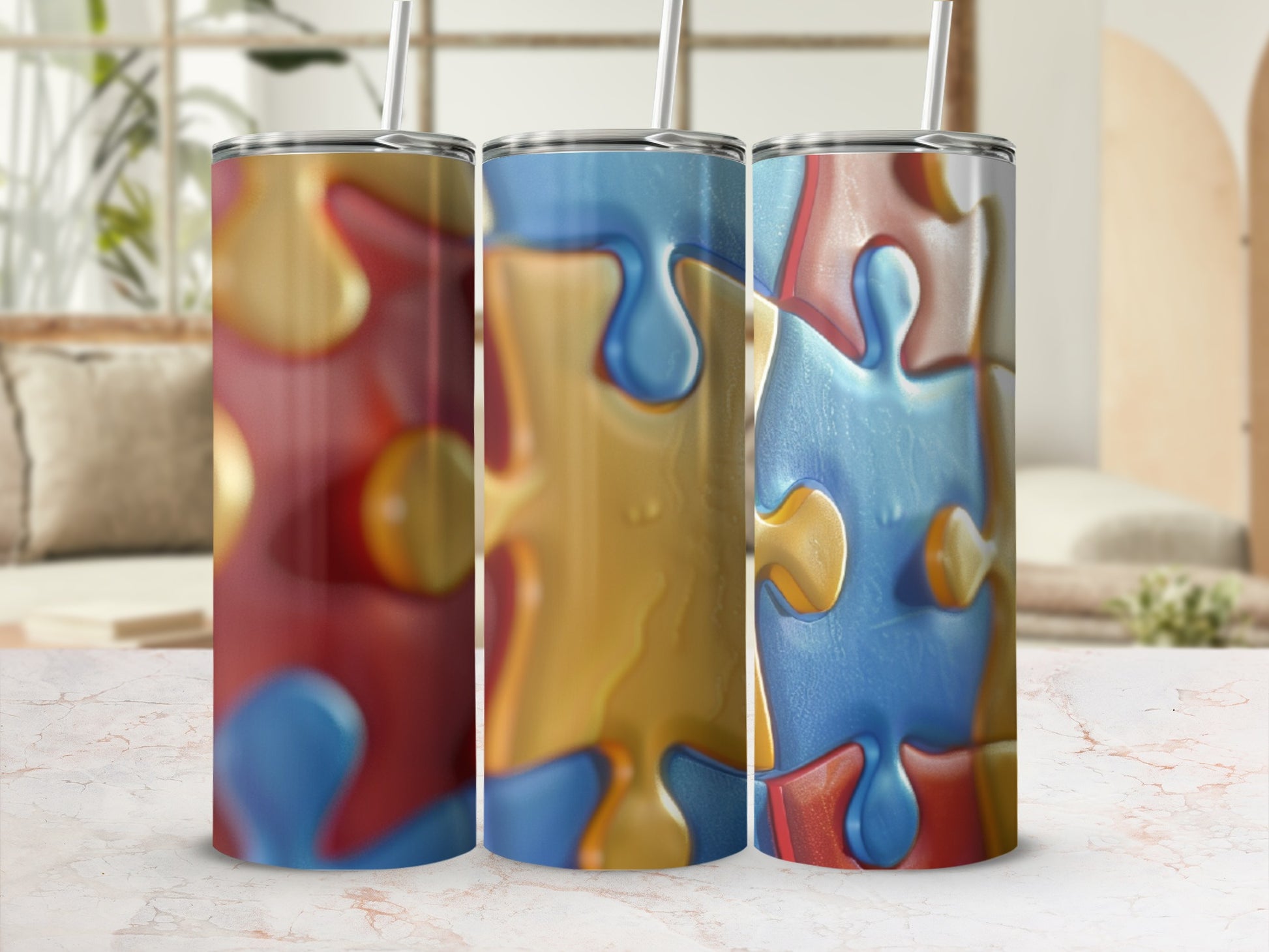 Three colorful puzzle piece tumblers with straws, displayed on a marbled surface.