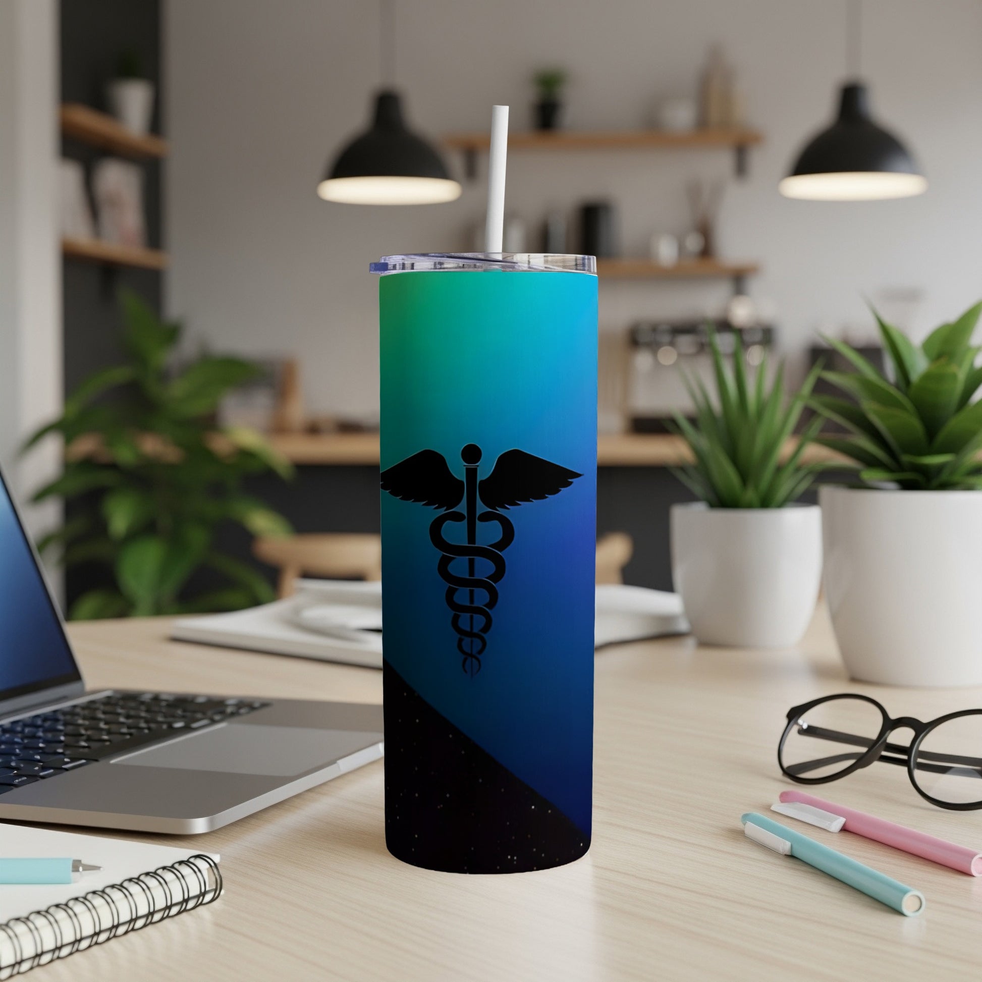 Blue and green gradient tumbler with caduceus symbol and straw.