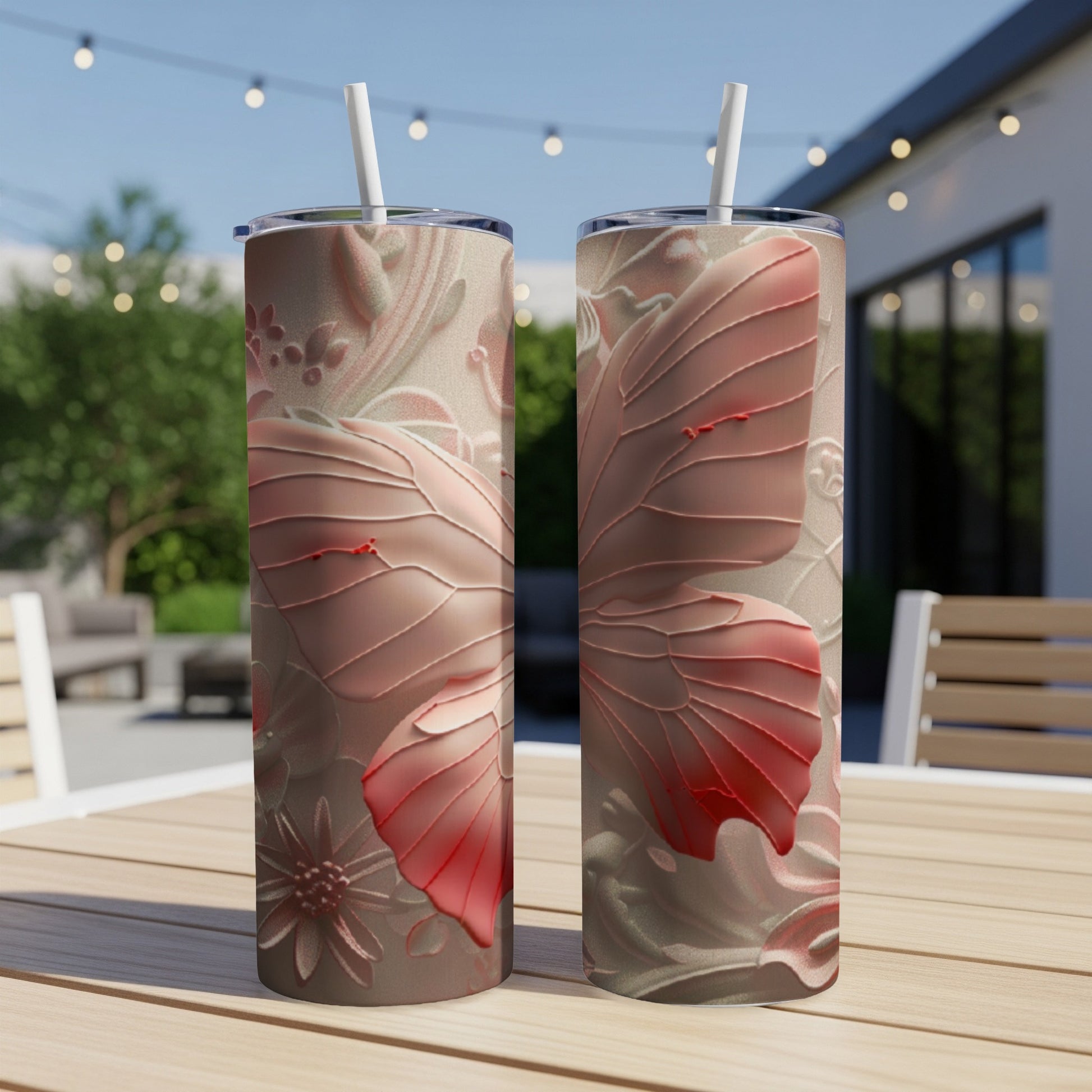 Two pink butterfly tumblers with floral embossed patterns on a table.
