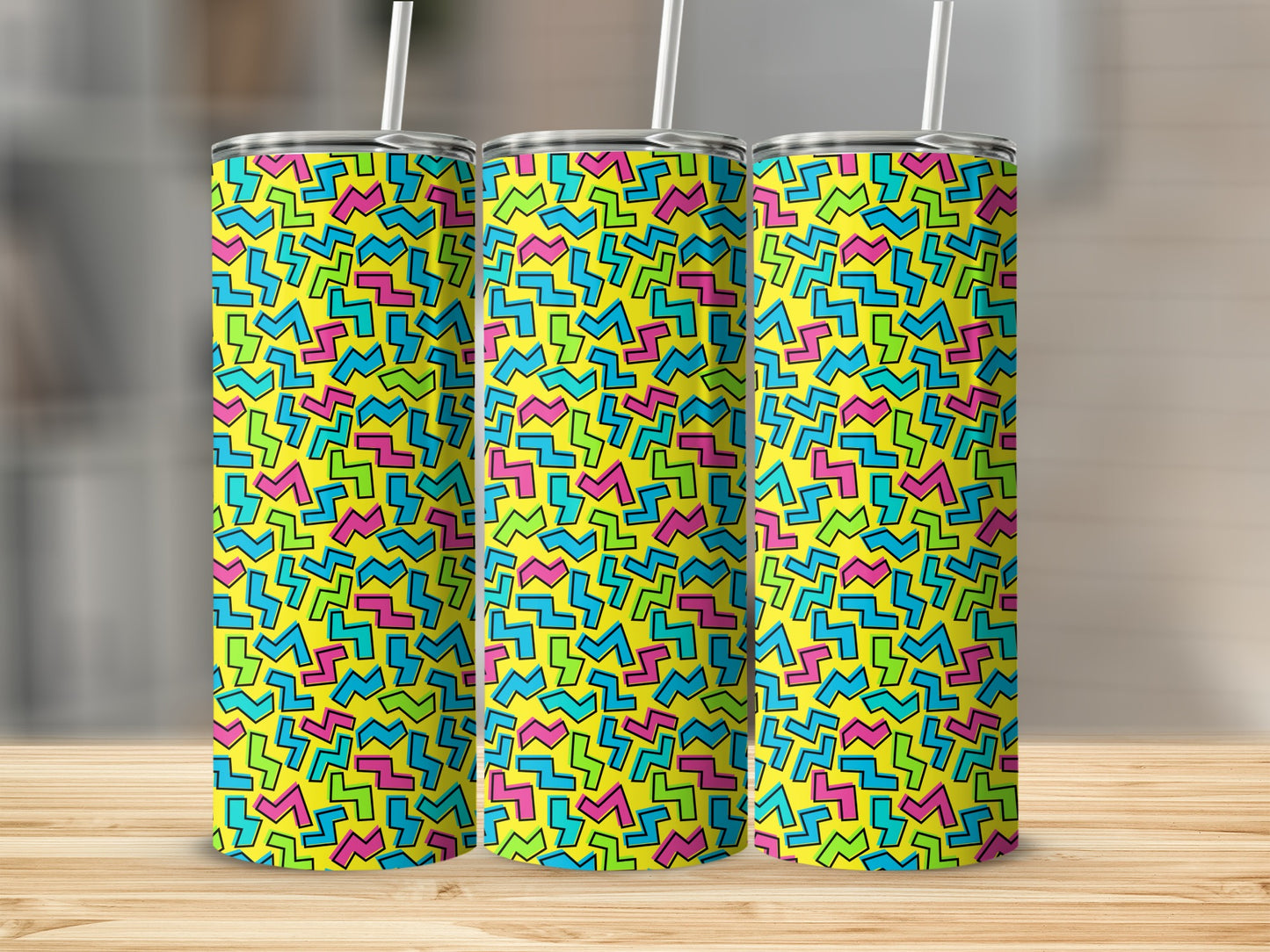 Three tumblers with yellow background and colorful geometric zigzag pattern.