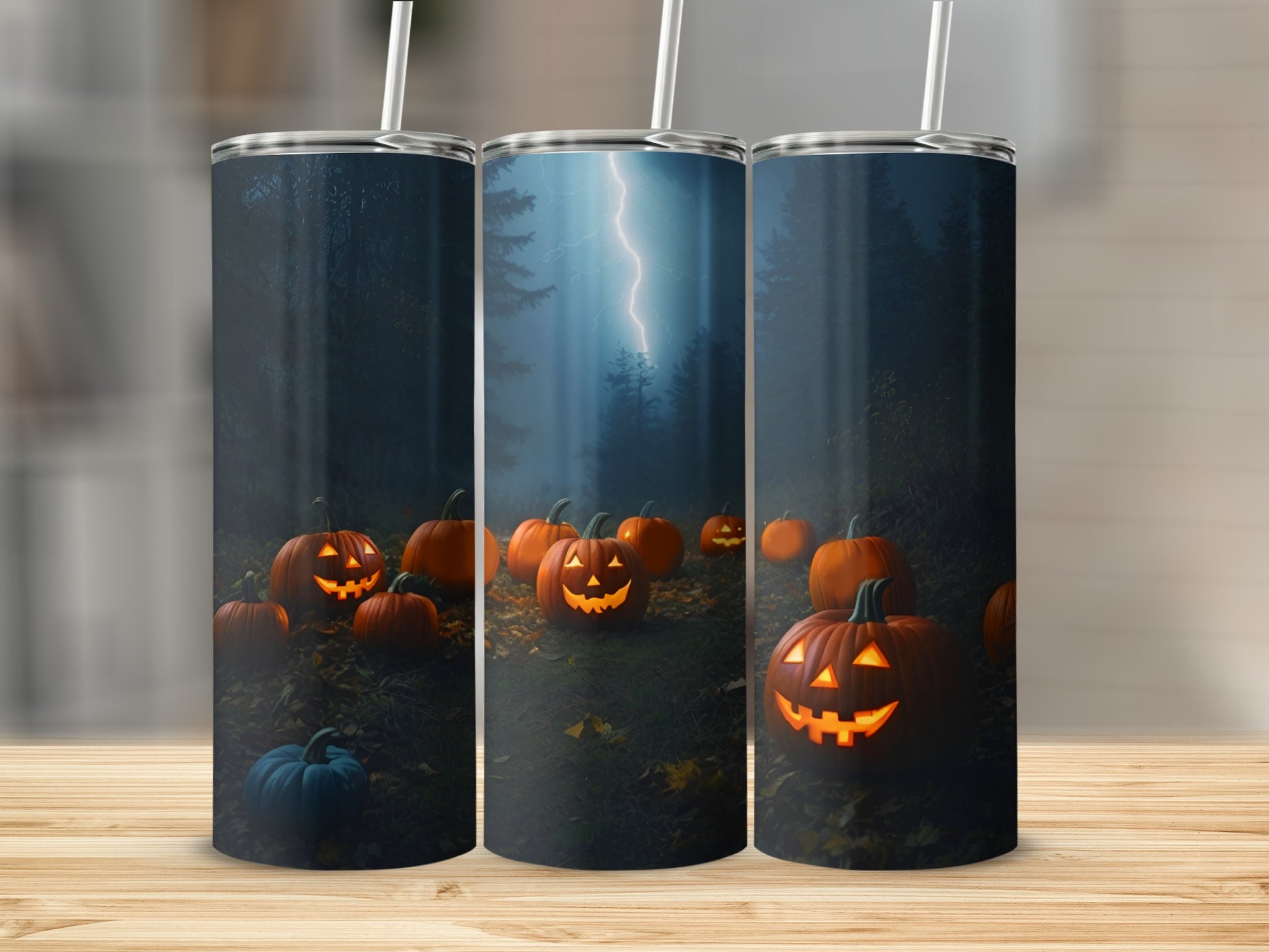 Three tumblers with a Halloween scene of glowing jack-o'-lanterns and lightning.