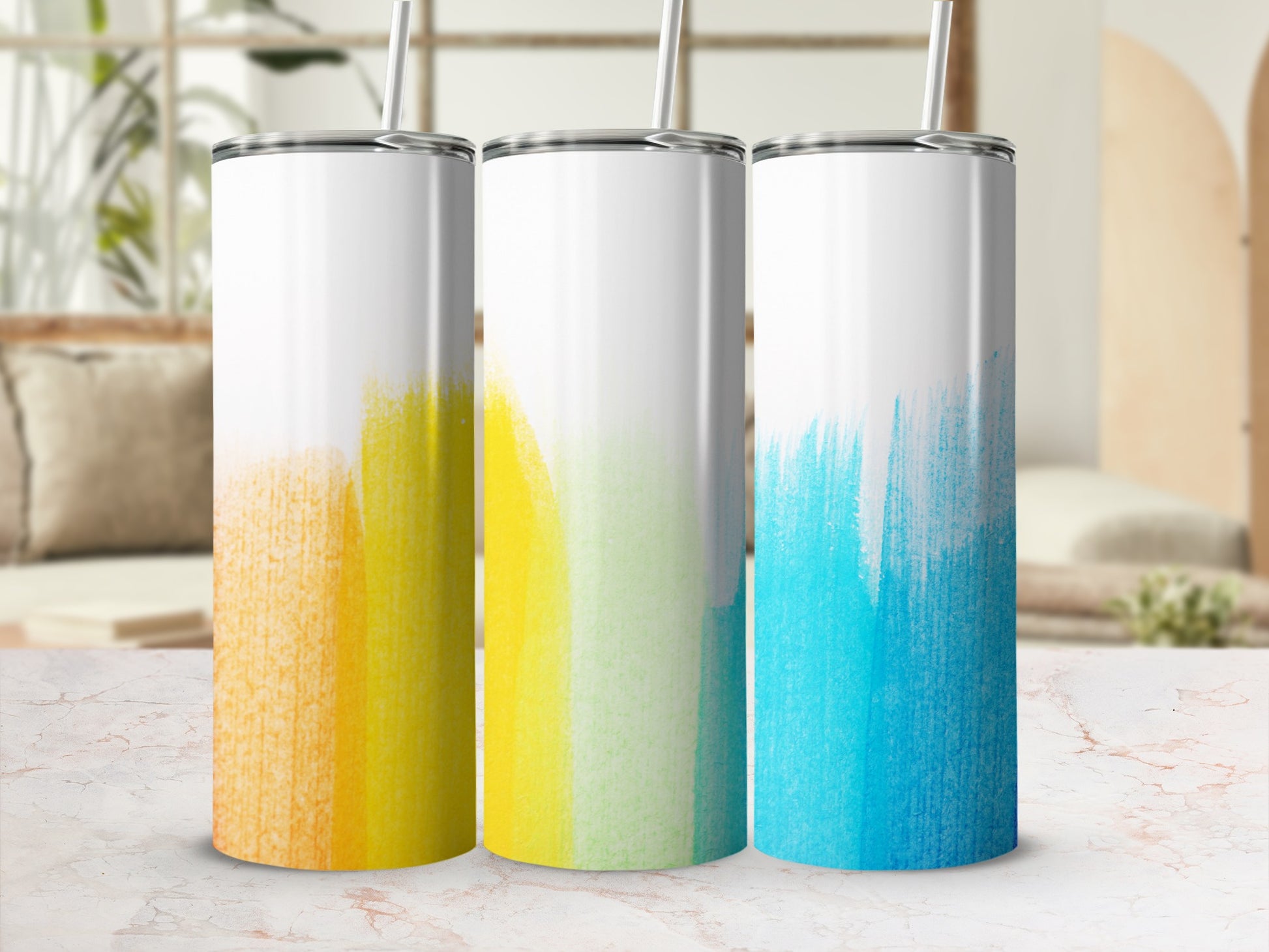 Three tumblers with colorful abstract paint strokes: orange, yellow-green, and blue.