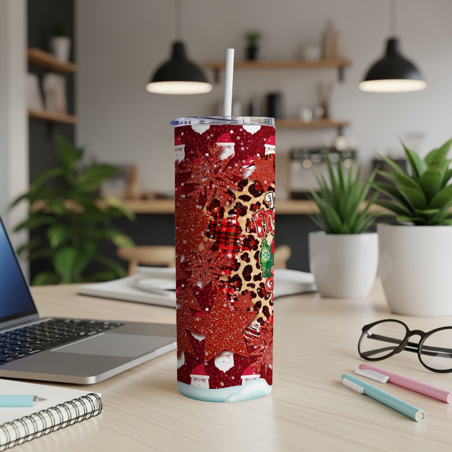 Santa and leopard print pattern on a tall, skinny tumbler with a straw.