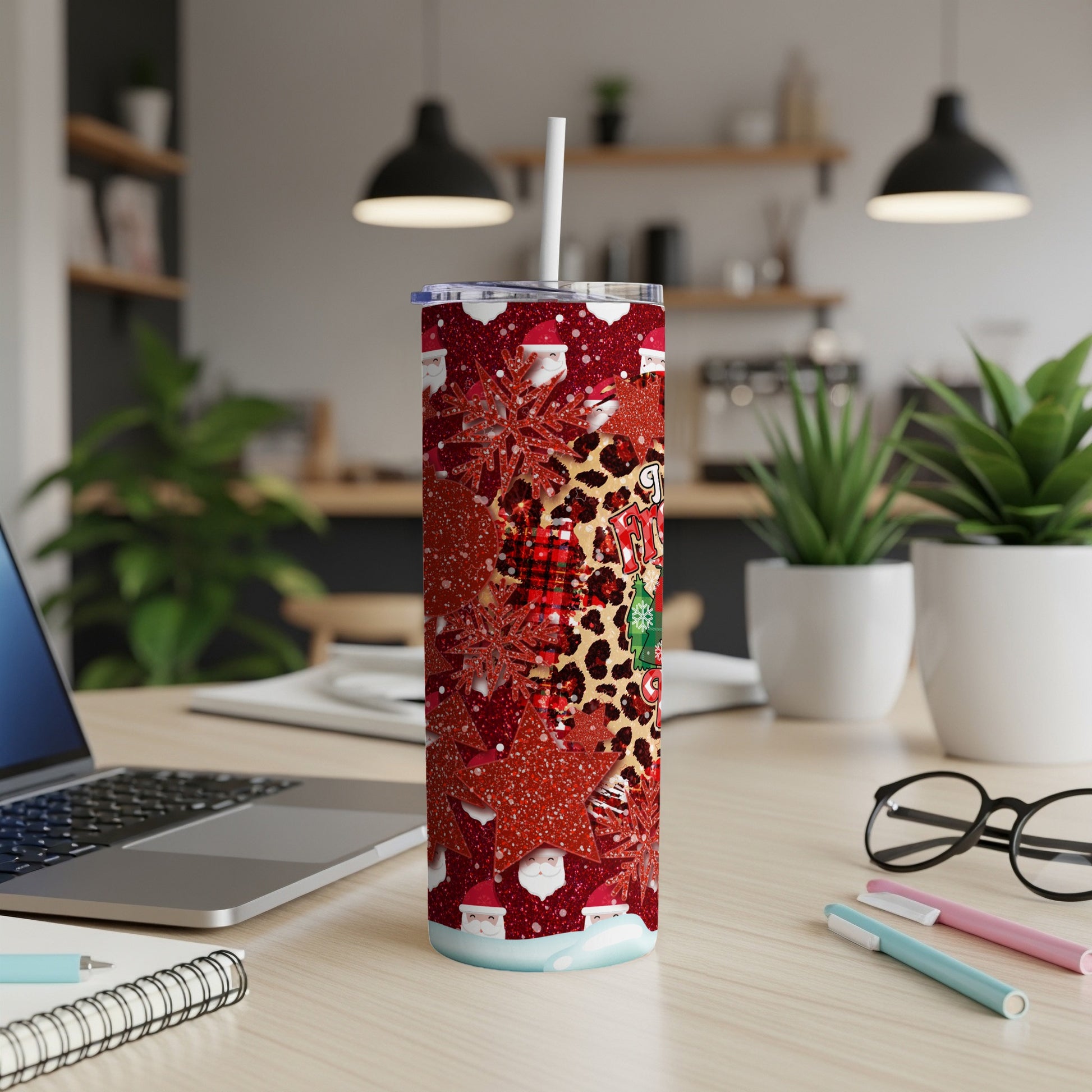 Santa and leopard print pattern on a tall, skinny tumbler with a straw.