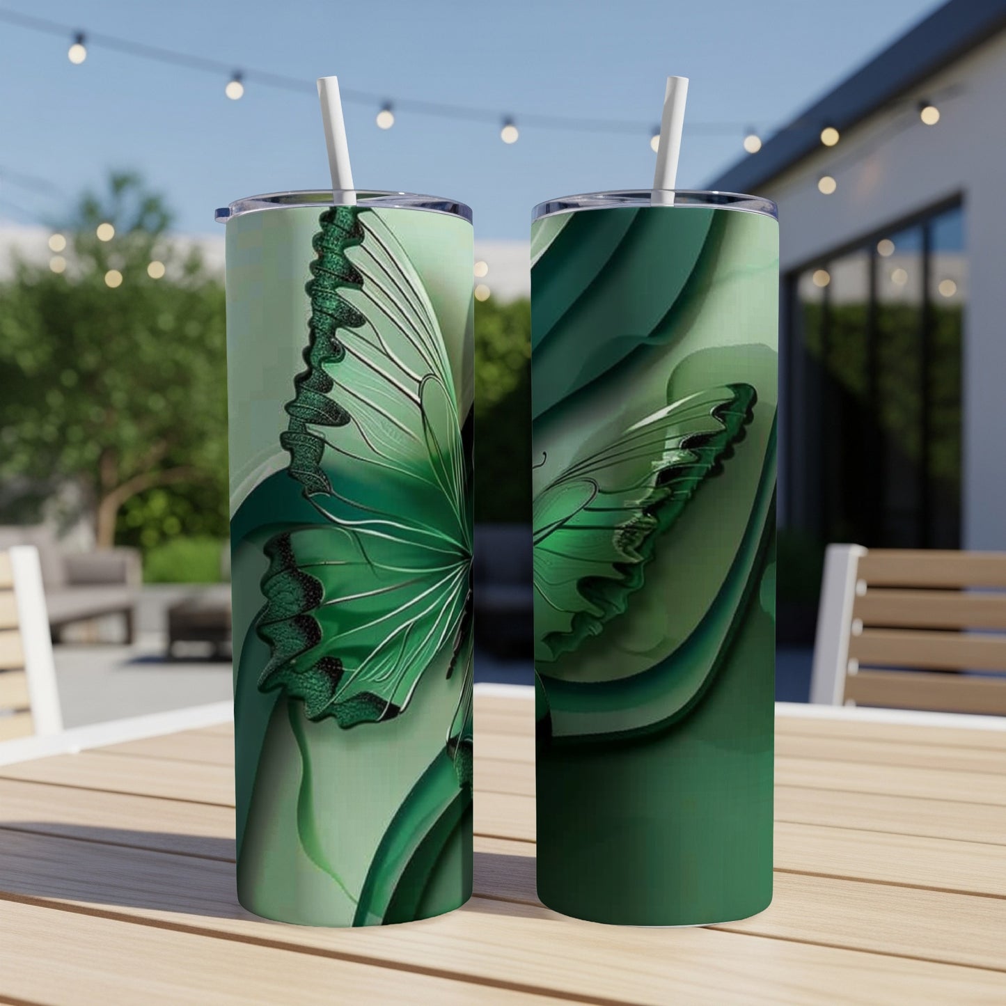 Two green tumblers with butterfly wing designs on a wooden table.
