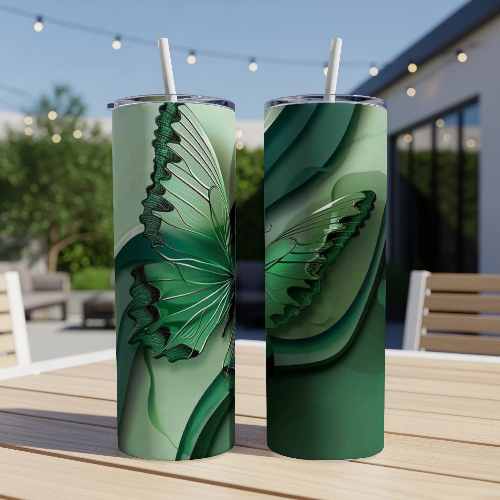 Two green tumblers with butterfly wing designs on a wooden table.