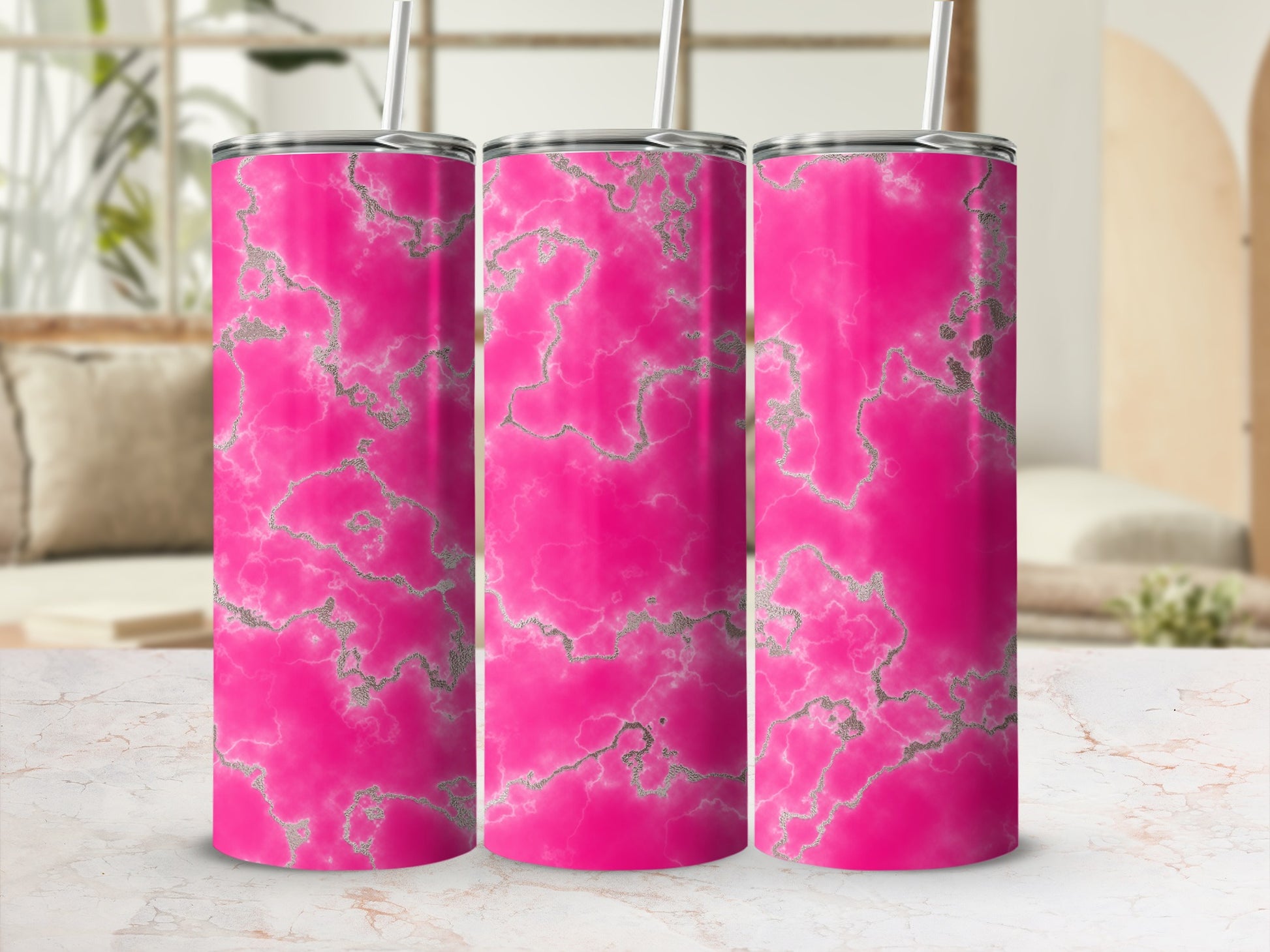 Three pink tumblers with silver marble pattern and straws.