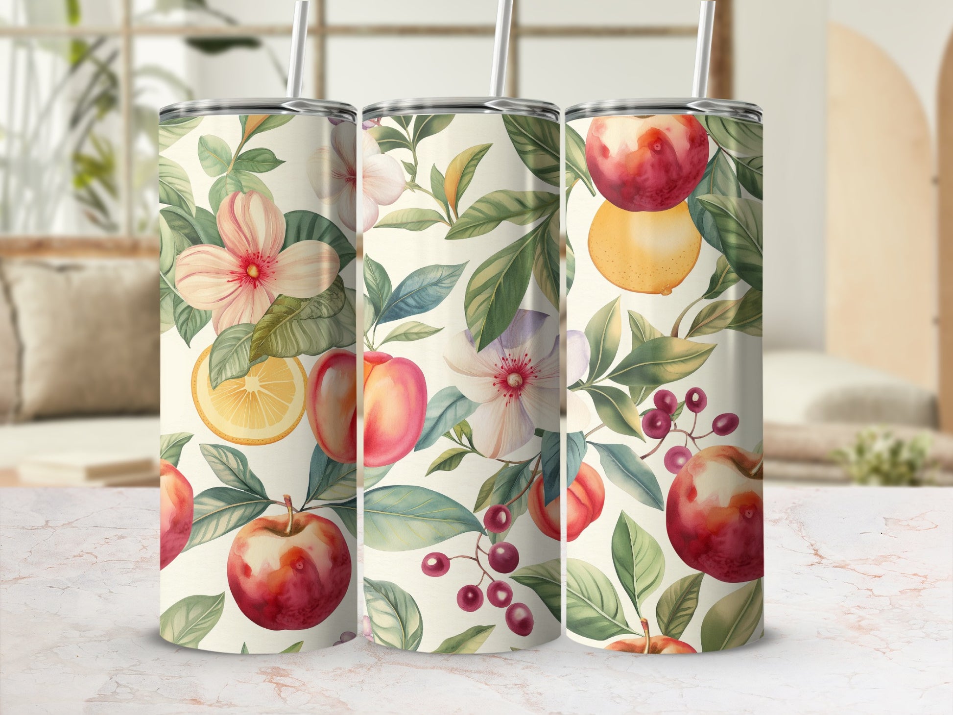Floral and fruit pattern on three tumblers with straws, set on a countertop.