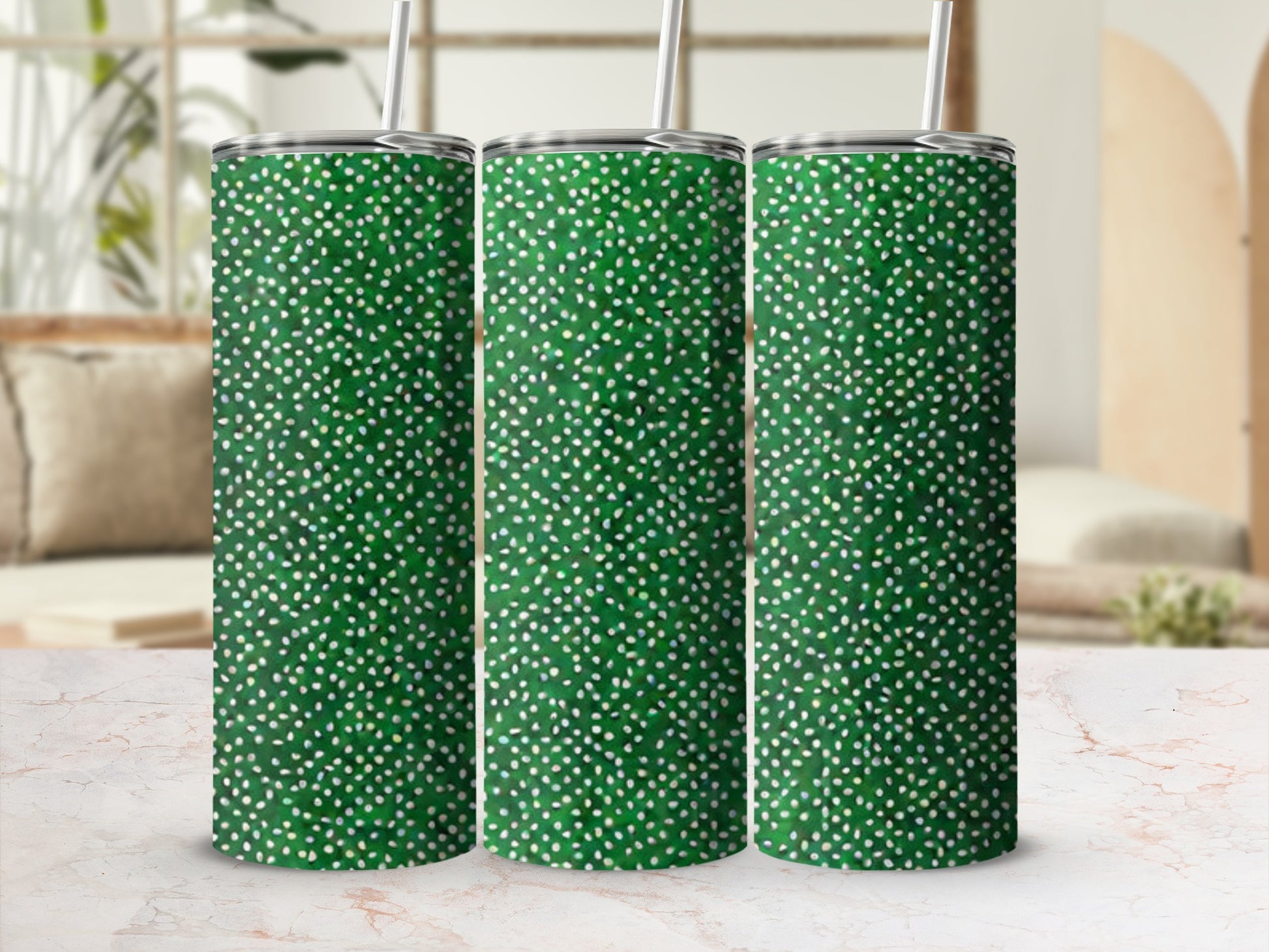Three green tumblers with white dot pattern and straws, displayed on a counter.