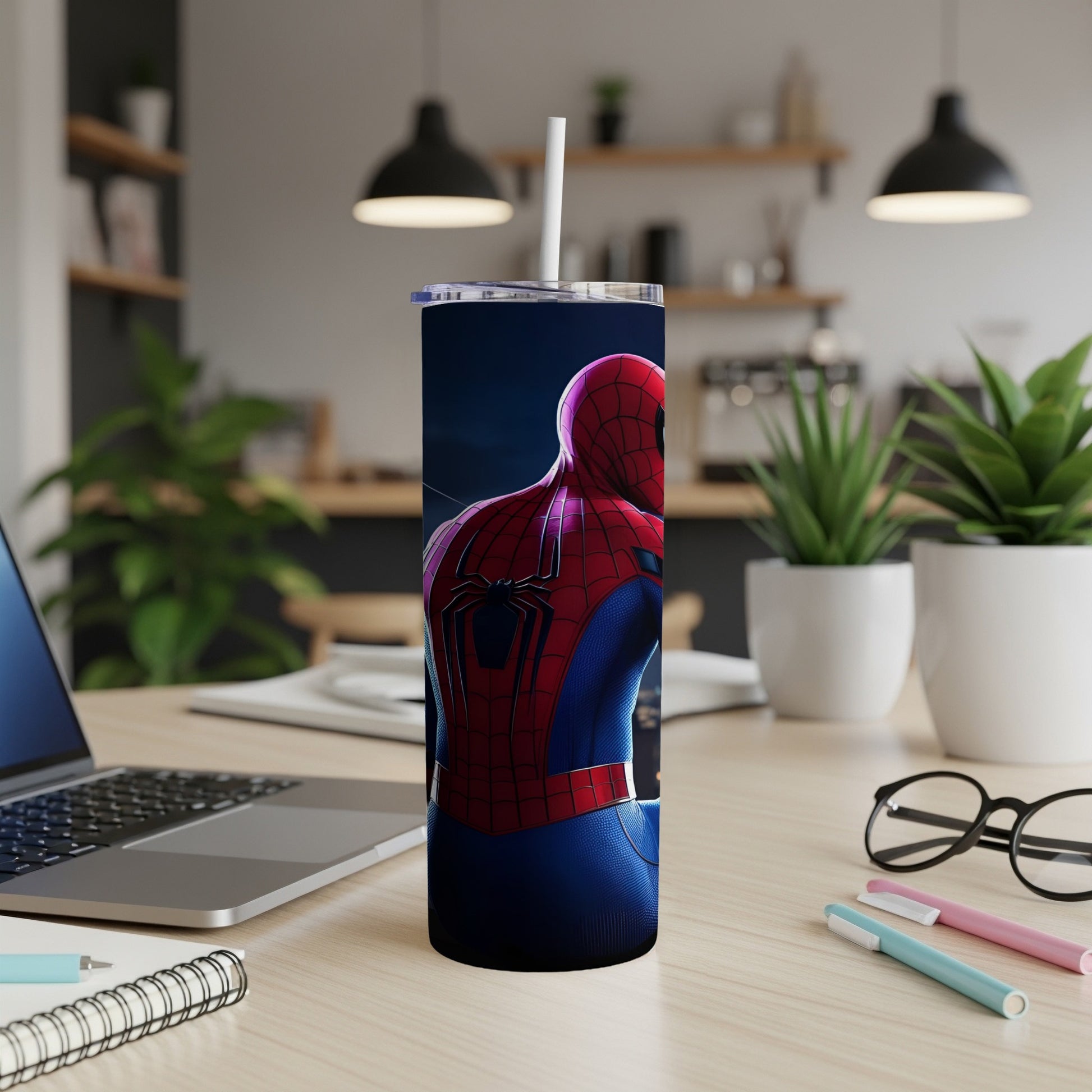 Spider-Man tumbler with straw on a desk.