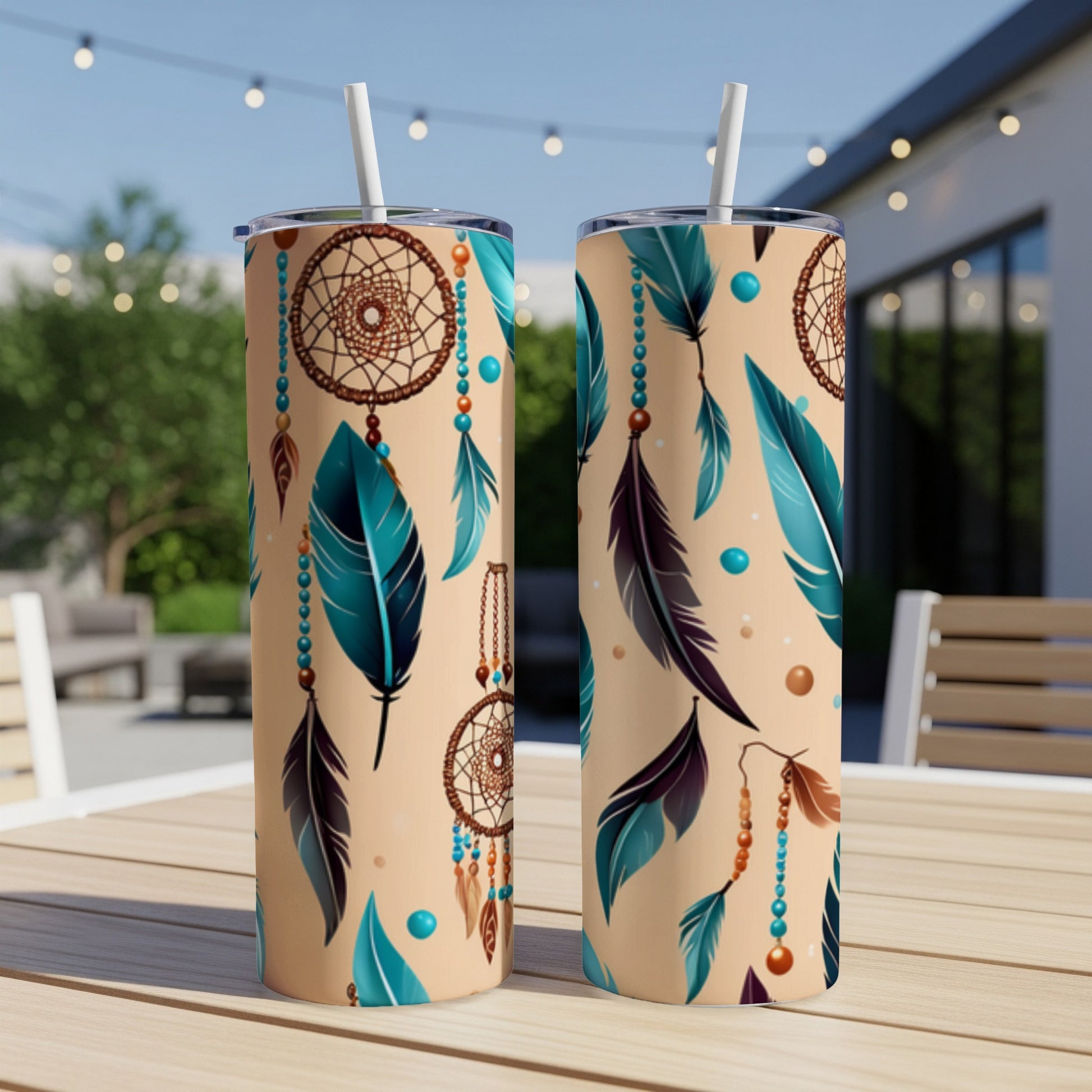 Two tall tumblers with dreamcatcher and feather pattern on a table.