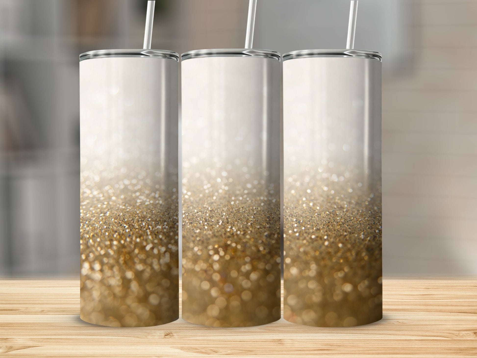 Three glitter tumblers with white lids and straws on a wooden surface.