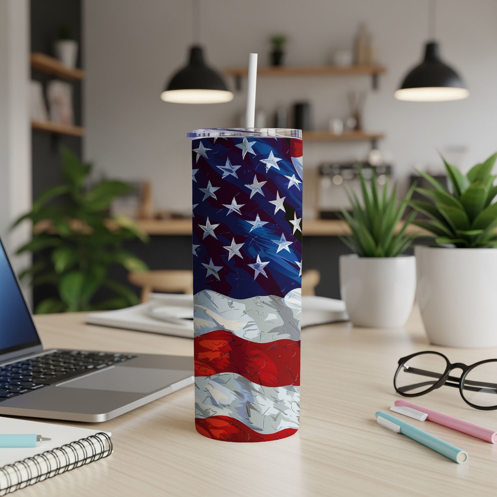 American flag tumbler with straw on desk with laptop.