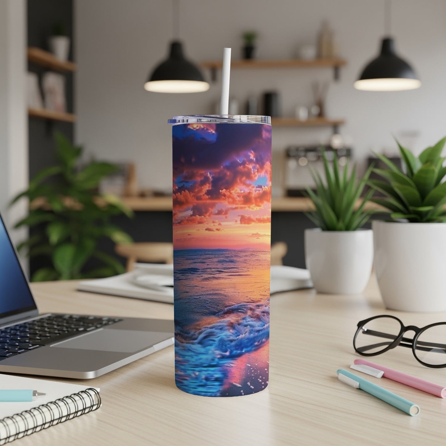Ocean sunset waves wrap around a blue tumbler with a straw.