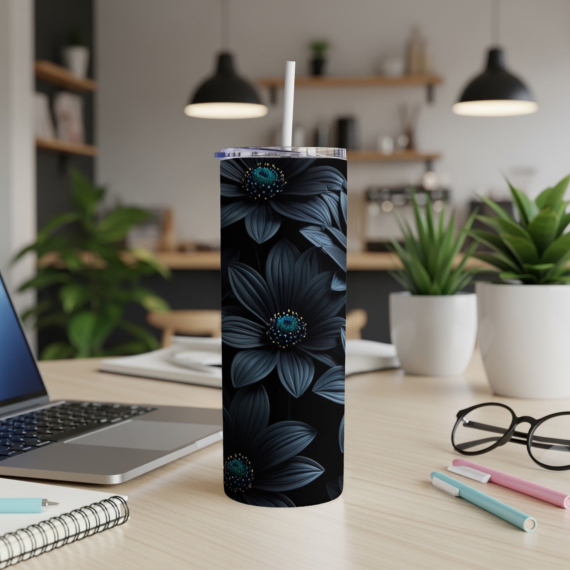 Black floral tumbler with white straw on a desk.