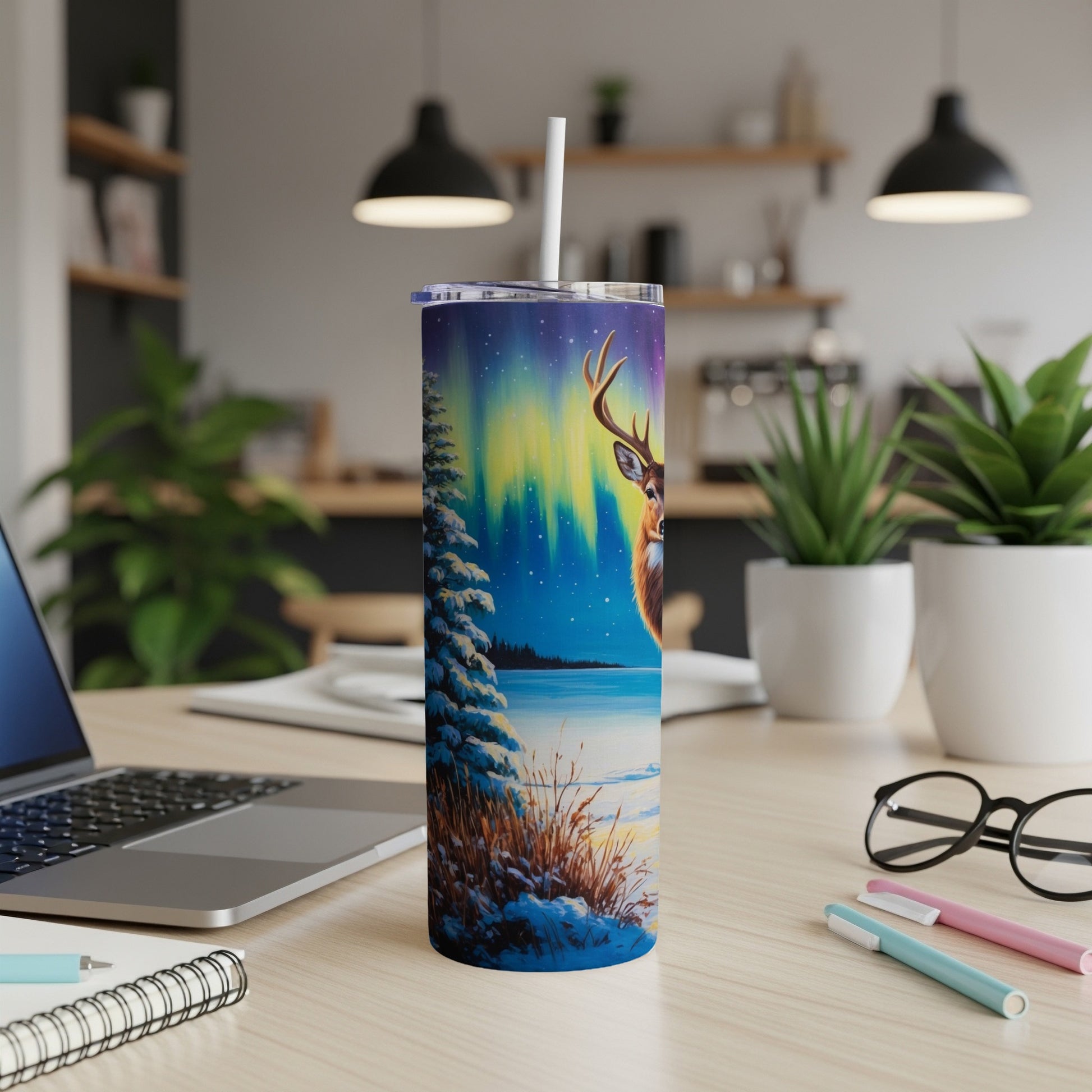 Deer and aurora borealis design on a white tumbler with a straw.
