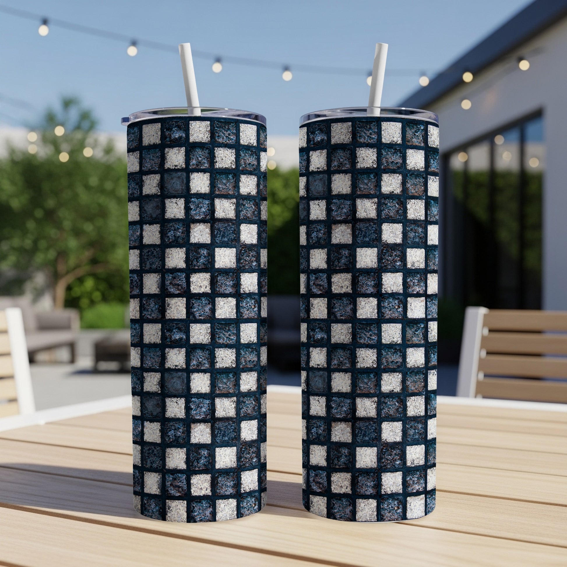 Two tumblers with a blue and white checkerboard mosaic pattern sit on a table.
