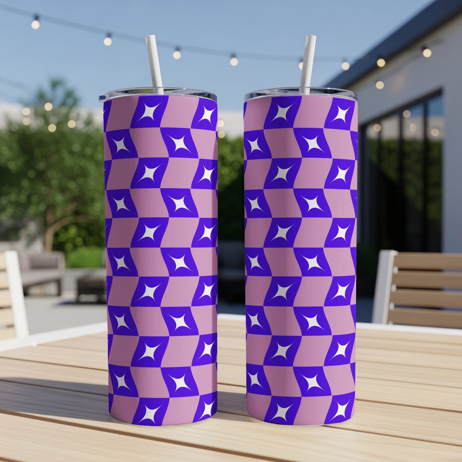 Two purple tumblers with a geometric white and purple pattern and straws.
