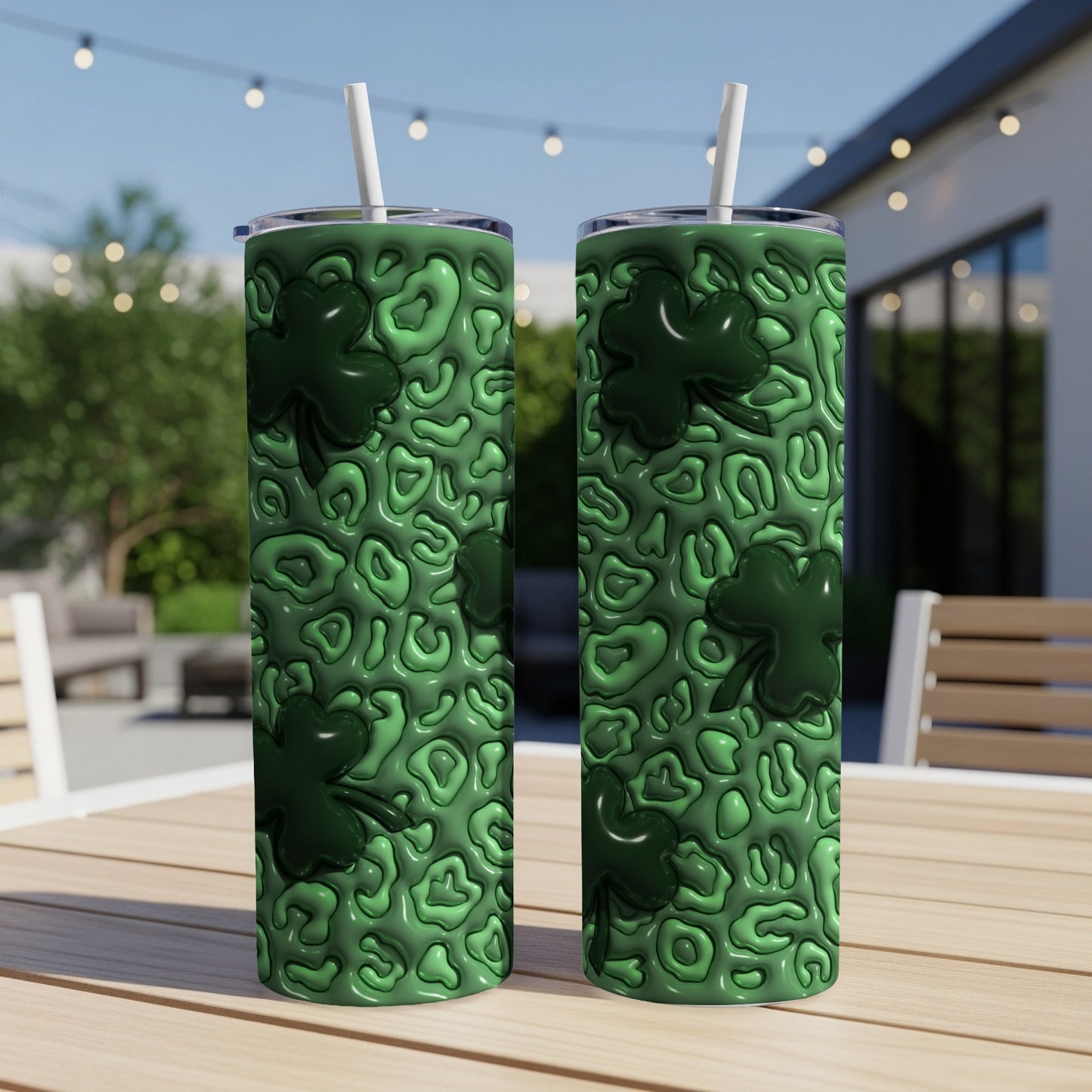 Green shamrock patterned tumbler with straw on a table.