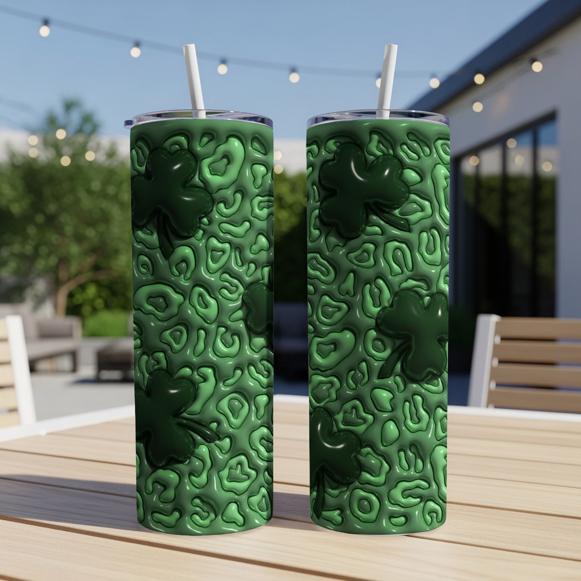 Green shamrock patterned tumbler with straw on a table.